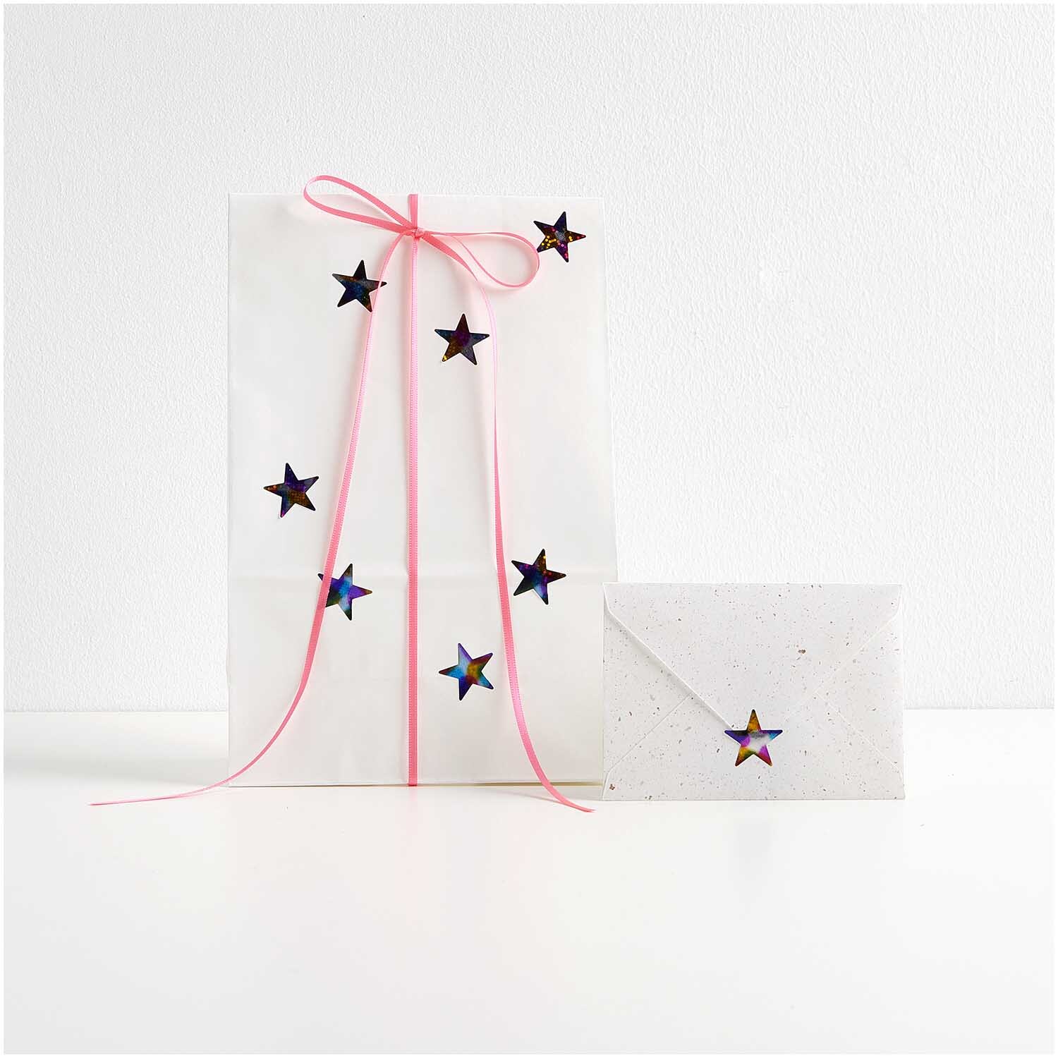Paper Poetry Mini-Sticker Sterne Rainbow auf der Rolle 120 Stück von Rico Design Paper Poetry Mini-Sticker Sterne Rainbow auf der Rolle: Geschenkverpackung mit bunten Sternstickern und rosa Schleife, 120 Stück von Rico Design.