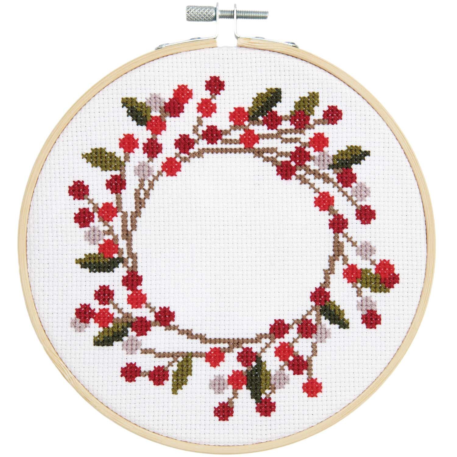 Stickpackung Hagebuttenkranz Bild Ø 15cm zeigt einen Kranz aus roten Beeren und grünen Blättern. Marke: Rico Design.