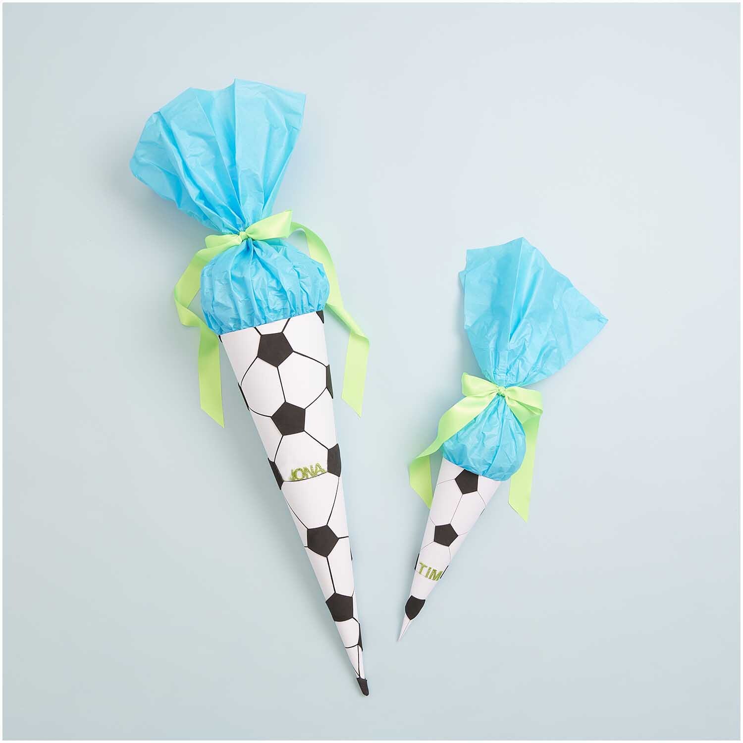 Paper Poetry Schultüte Rohling 70cm Farbe Weiß von Rico Design Paper Poetry Schultüte Rohling, 70cm, mit Fußballmuster, blauem Tüll und grünem Band dekoriert.