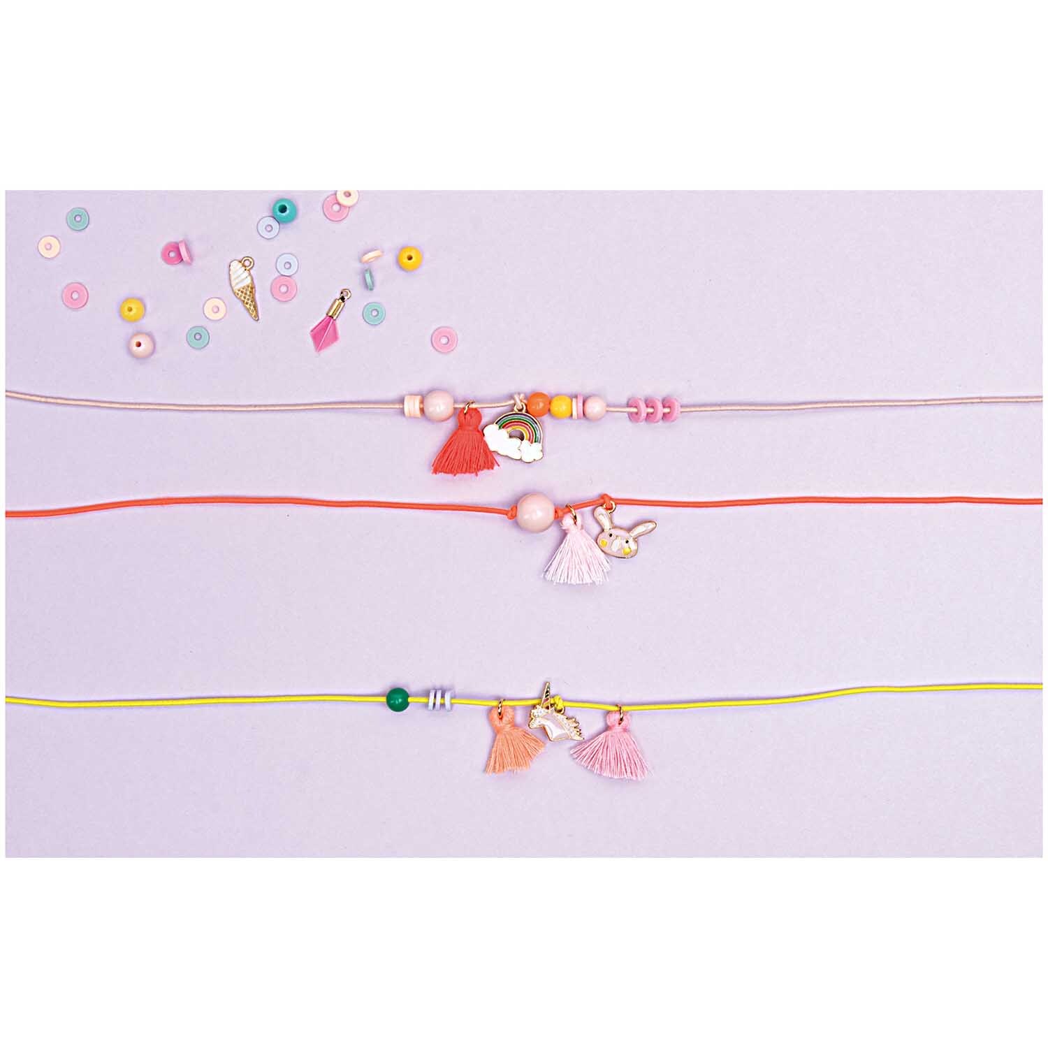 Hutgummiband 1mm 5m: Rosa Bänder mit bunten Perlen und Anhängern auf hellem Hintergrund. Ideal für kreative Bastelprojekte.