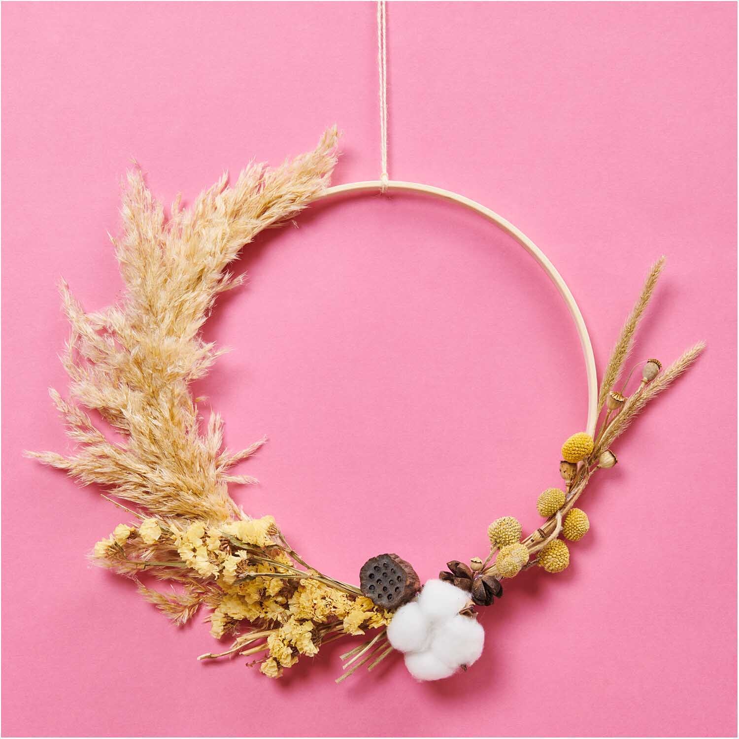 Trockenblumenstrauß natur-gelb 30cm 13-teilig von Rico Design Trockenblumenstrauß natur-gelb 30cm von Rico Design: Ein dekorativer Kranz aus getrockneten Blumen auf rosa Hintergrund, 13-teilig.