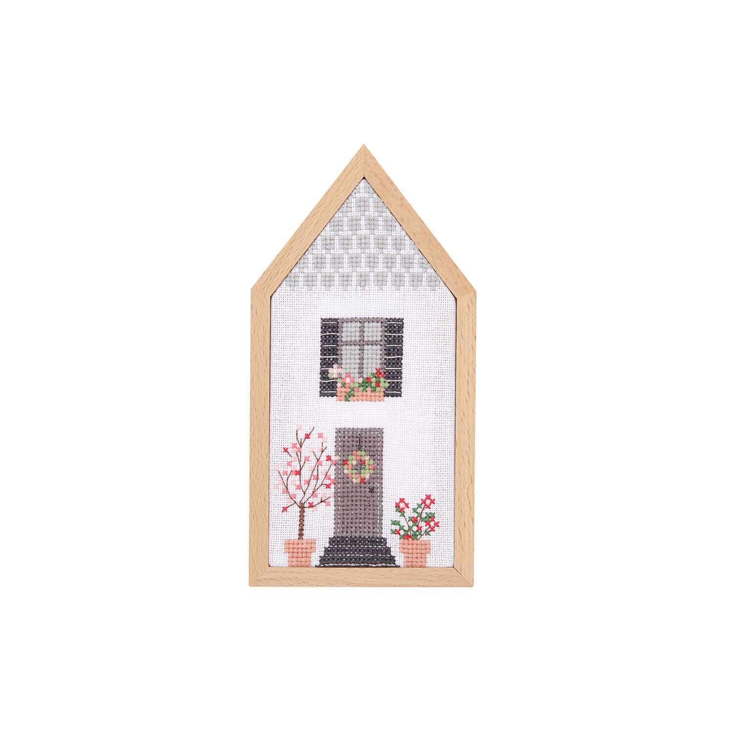 Cadre décoratif Maison format portrait Taille 9x18cm from Rico Design Dekorahmen Haus Hochformat zeigt ein gesticktes Haus mit Blumen in einem Holzrahmen von Rico Design.
