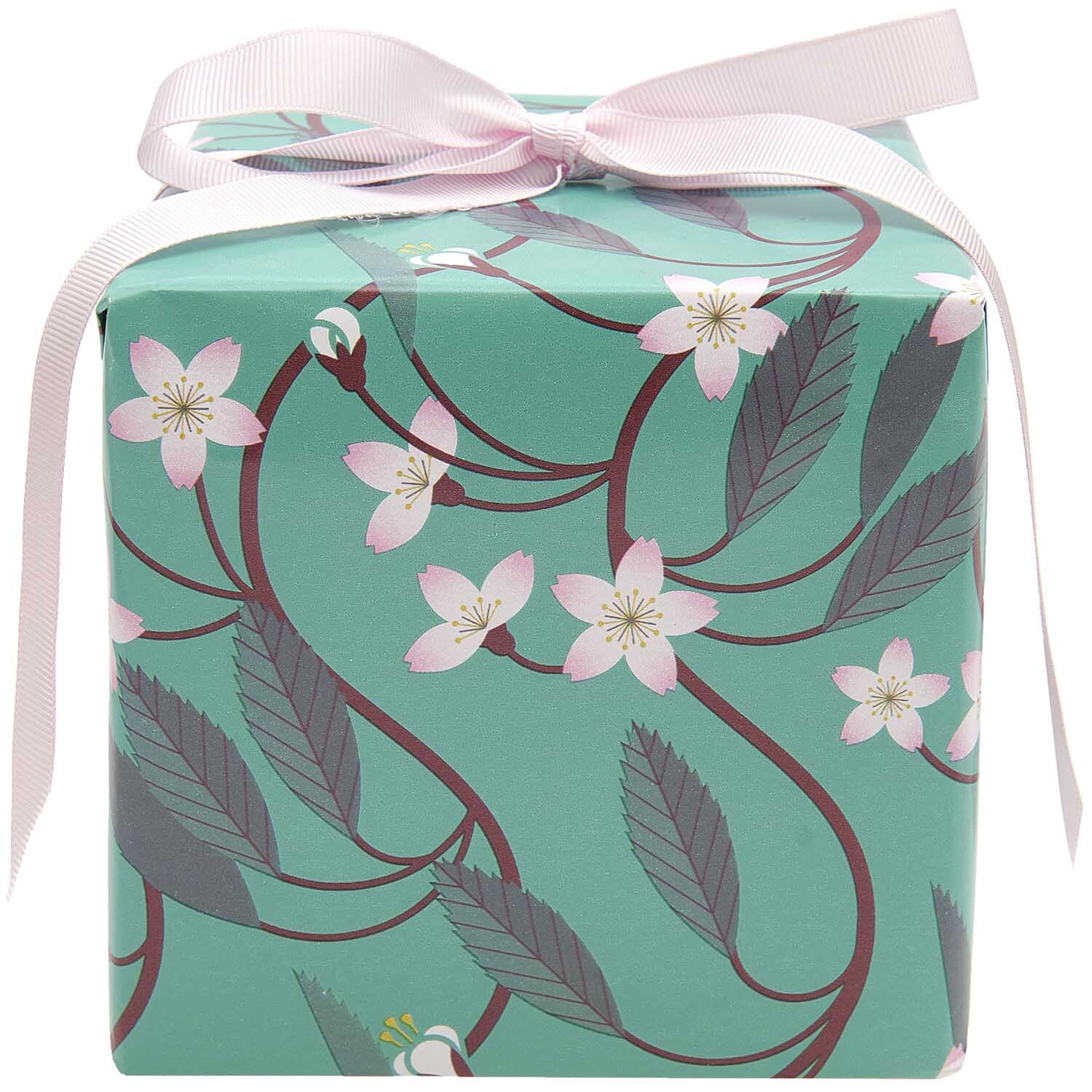 Paper Poetry Geschenkpapier Kirschblütenranken 200x70cm 80g/m² von Rico Design Paper Poetry Geschenkpapier mit Kirschblütenranken auf mintfarbenem Hintergrund, verpackt mit rosa Schleife. Ideal für stilvolle Geschenke.