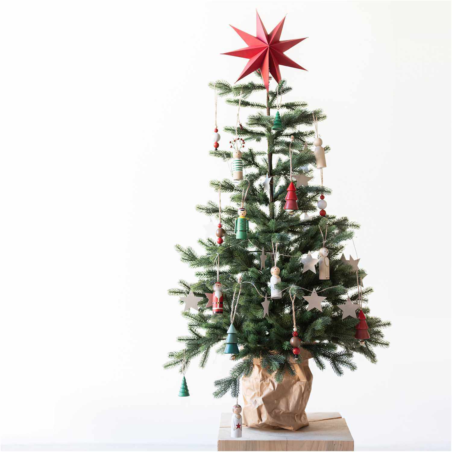 Holzhänger Nussknacker rot 3x9cm von Rico Design Holzhänger Nussknacker rot 3x9cm von Rico Design schmückt einen Weihnachtsbaum mit roten und weißen Ornamenten und einem roten Stern an der Spitze.
