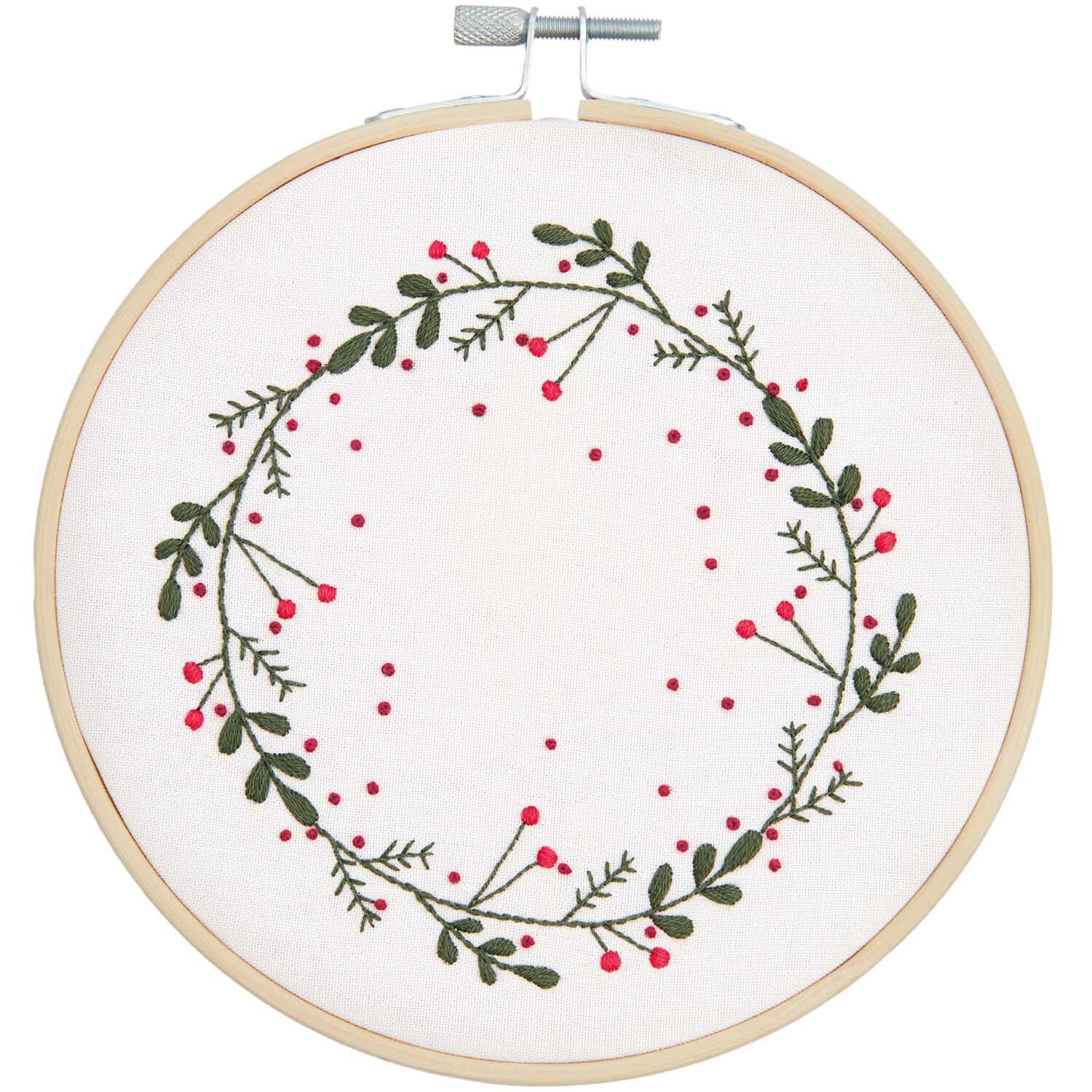 Stickpackung Kranz Bild Ø 15cm zeigt einen grünen Kranz mit roten Beeren auf weißem Stoff, von Rico Design.