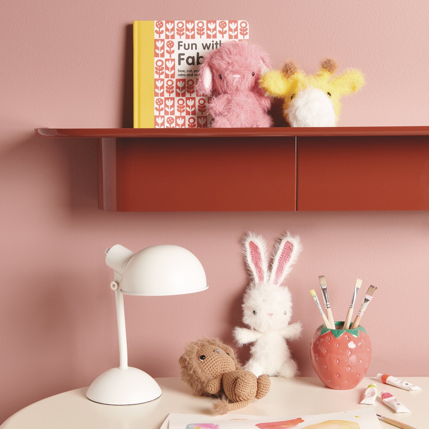 Ricorumi Furry Animals auf Regal mit rosa Wand, umgeben von Deko und weißer Tischlampe.