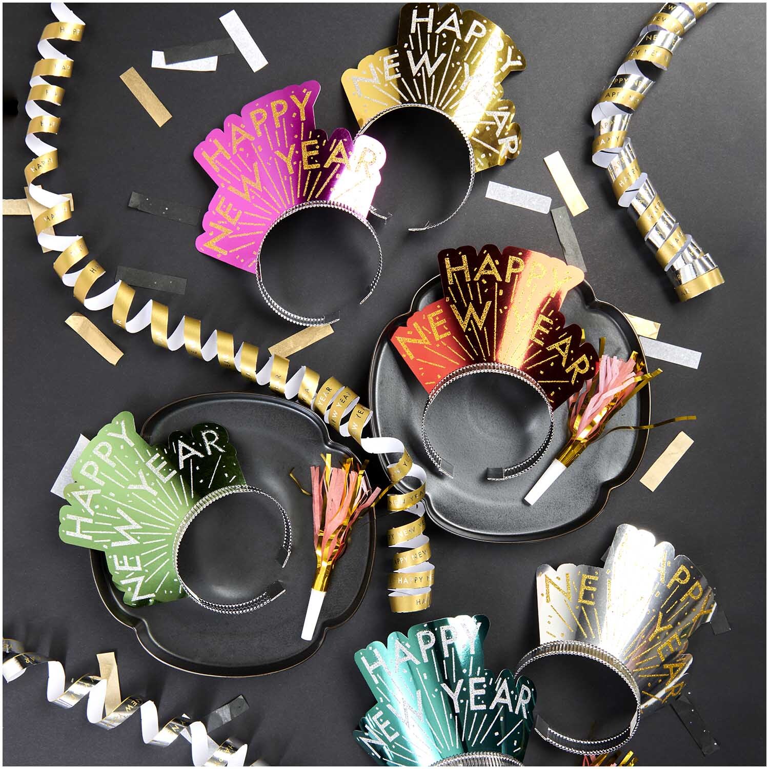Luftschlangen Happy New Year 3,8m von Rico Design Luftschlangen Happy New Year 3,8m von Rico Design auf schwarzem Hintergrund mit bunten Partyhüten und goldenen Dekorationen.