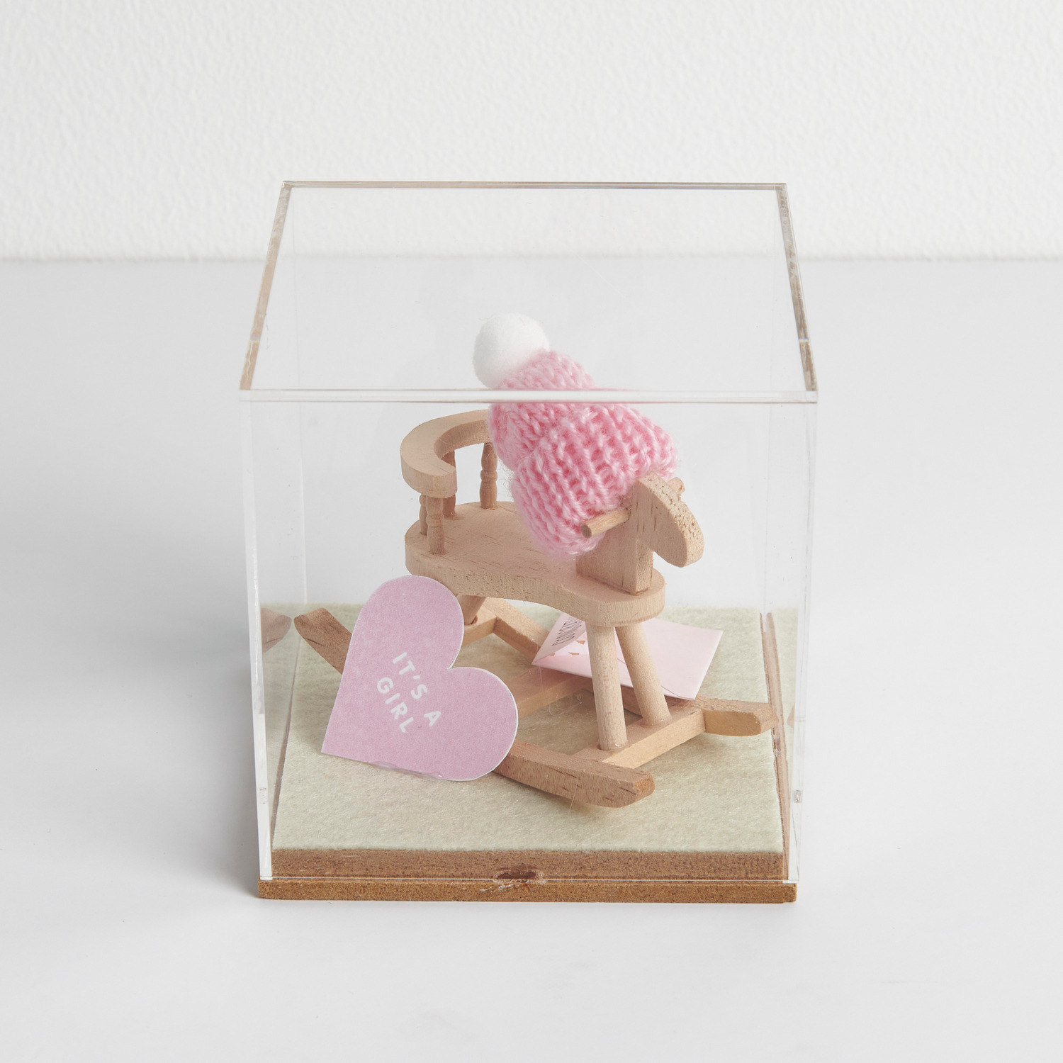 Figurico Dekohaube Würfel Größe 6x6x6,5cm von Rico Design Figurico Dekohaube Würfel zeigt ein Holzschaukelpferd mit rosa Mütze und Herz mit "It's a Girl". Ideal als Geschenk zur Geburt.