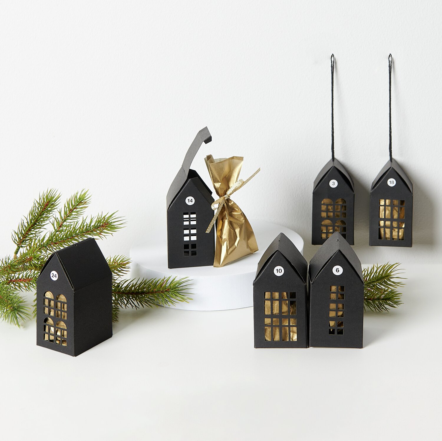 Paper Poetry Papphäuser-Set vorgestanzt 9x4,5x4,5cm 6 Stück Farbe Schwarz von Rico Design Paper Poetry Papphäuser-Set: Schwarze, vorgestanzte Adventskalender-Häuser von Rico Design, dekorativ aufgestellt mit Tannenzweig.