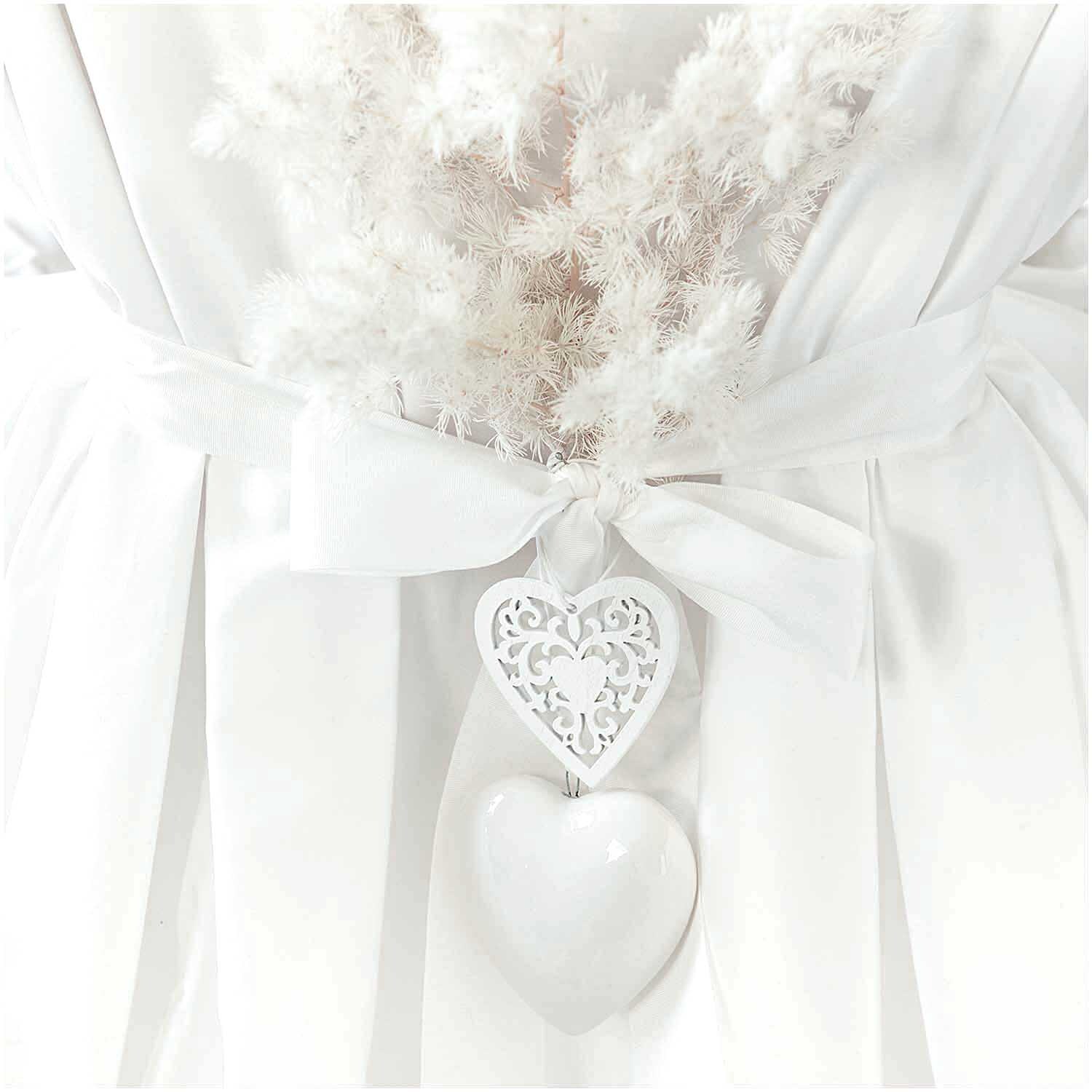 Holzanhänger Ornament Weiß 1 Stück Größe M = 6x6cm von Rico Design Holzanhänger Ornament Weiß von Rico Design: Filigranes Herzdesign an weißem Band, dekorativ an einem Strauß aus weißen Trockenblumen befestigt.