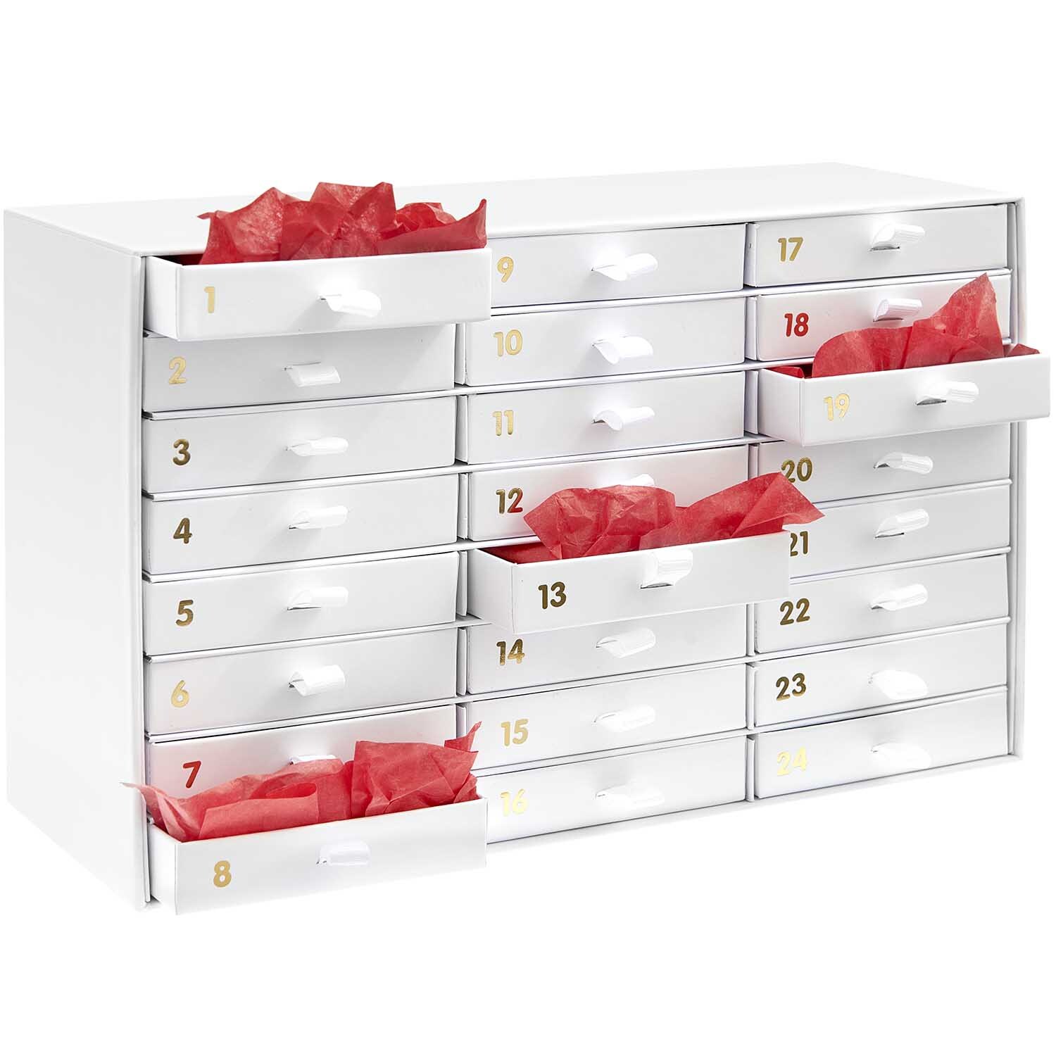 Adventskalender Box weiß-gold 16x26x9,5cm von Rico Design Adventskalender Box mit 24 weißen Schubladen und goldenen Zahlen, gefüllt mit rotem Papier. Ideal für kreative Weihnachtsüberraschungen.