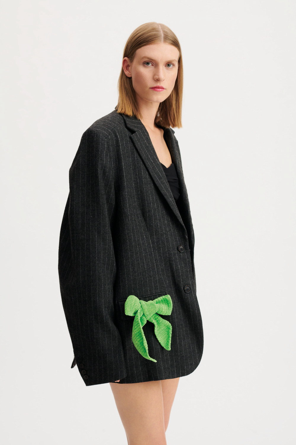 Ricorumi Nilli Nilli 25g Farbe Neon Grün von Rico Design Ricorumi Nilli Nilli Häkelset zeigt eine neon grüne Schleife an einem schwarzen Blazer.