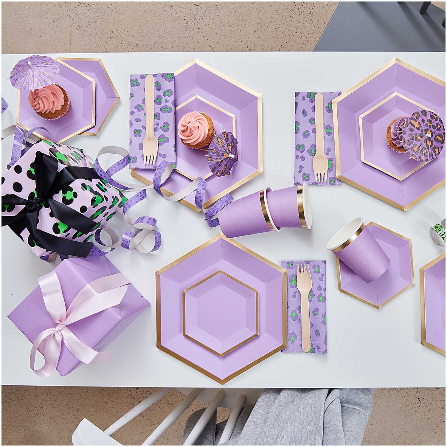 Paper Poetry Geschenkpapier flieder 70cm 3m 70g/m² von Rico Design Paper Poetry Geschenkpapier in Flieder, umgeben von dekorativen Tellern, Bechern und Besteck in passendem Design.