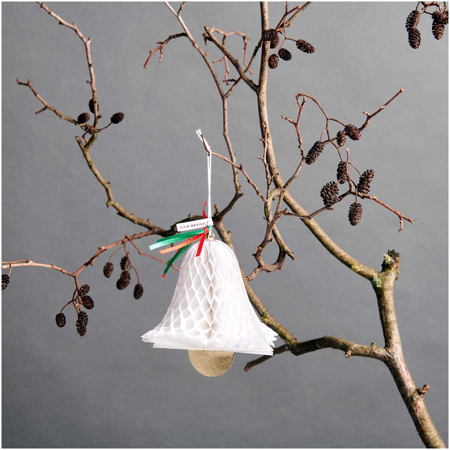 Paper Poetry Kartenset mit Pop-Up Anhänger Glocke B6 von Rico Design Paper Poetry Kartenset mit Pop-Up Anhänger Glocke B6, weiß, an einem kahlen Ast hängend.