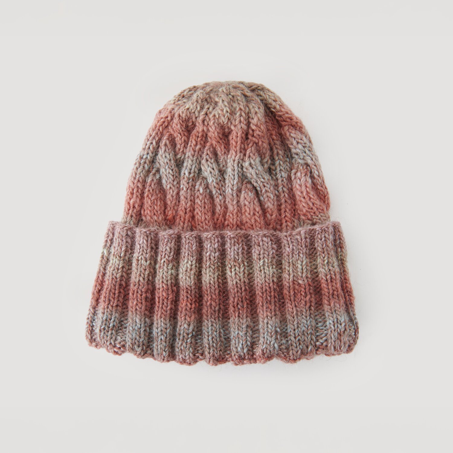 Creative Melange Alpaca Wonderball dk 100g 300m Farbe Spring von Rico Design Strickmütze in warmen Erdtönen mit Zopfmuster. Marke: Modell Legeware. Perfekt für kalte Tage, bietet Stil und Komfort. Ideal für Herbst- und Wintergarderoben.