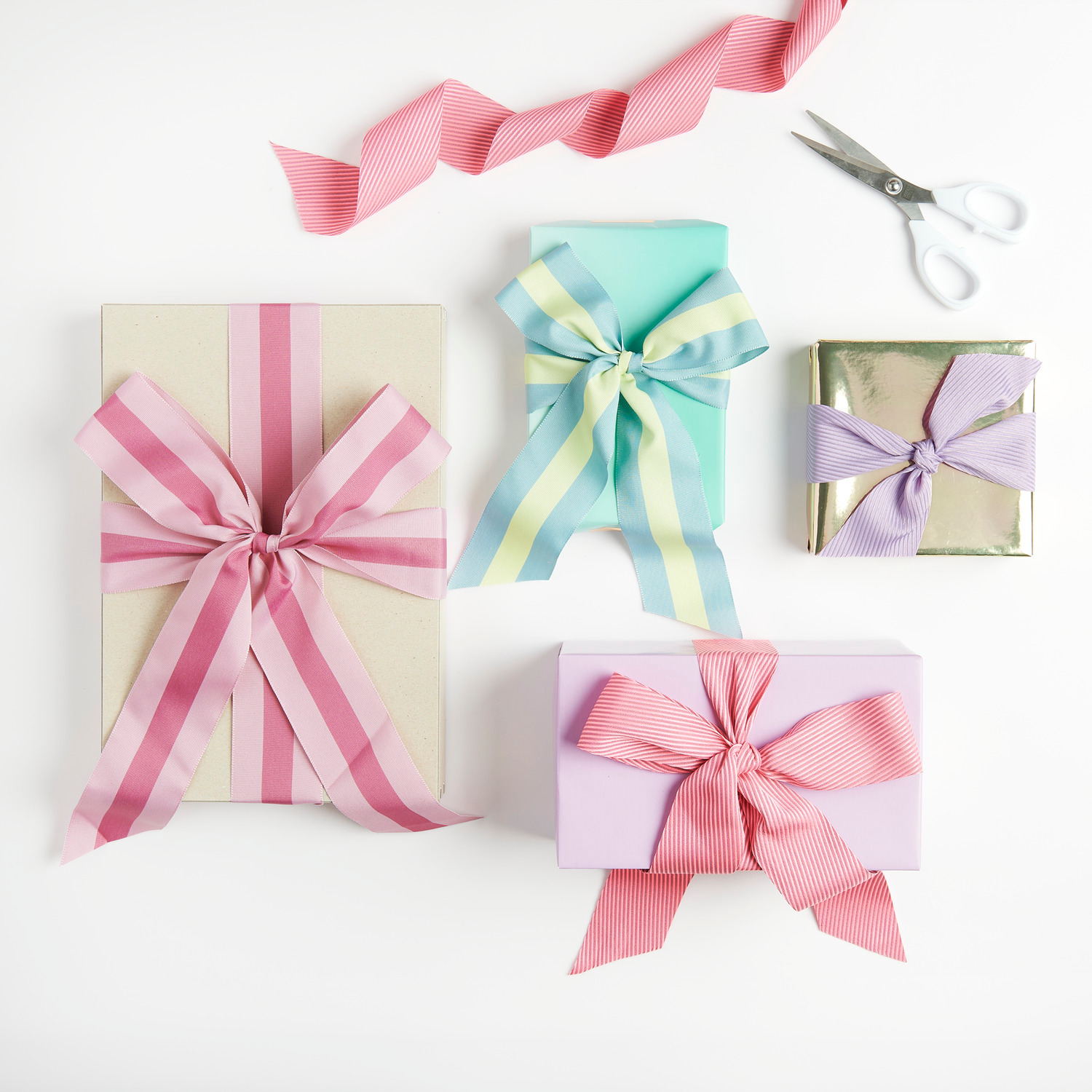 Paper Poetry Webband diagonale Streifen 50mm 3m Farbe Mauve/Neon Pink von Rico Design Webband Streifen Altrosa/Violett: Geschenkverpackungen mit farbigen Bändern, Schere im Hintergrund.