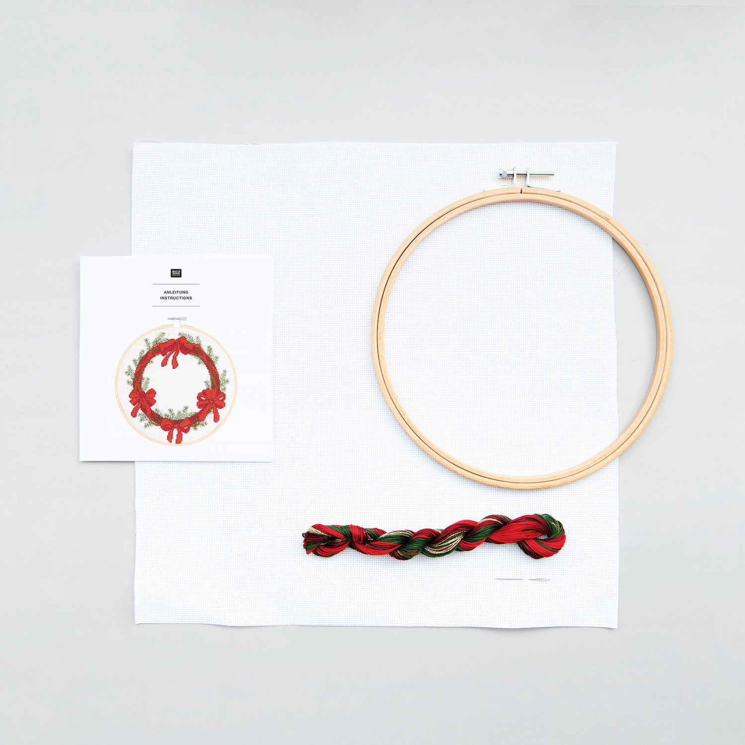 Stickpackung Bild Kranz mit Schleifen Ø20cm von Rico Design Stickpackung Bild Kranz mit Schleifen von Rico Design: Stickrahmen, Garn und Anleitung auf weißem Hintergrund. Ideal für kreative Handarbeiten.