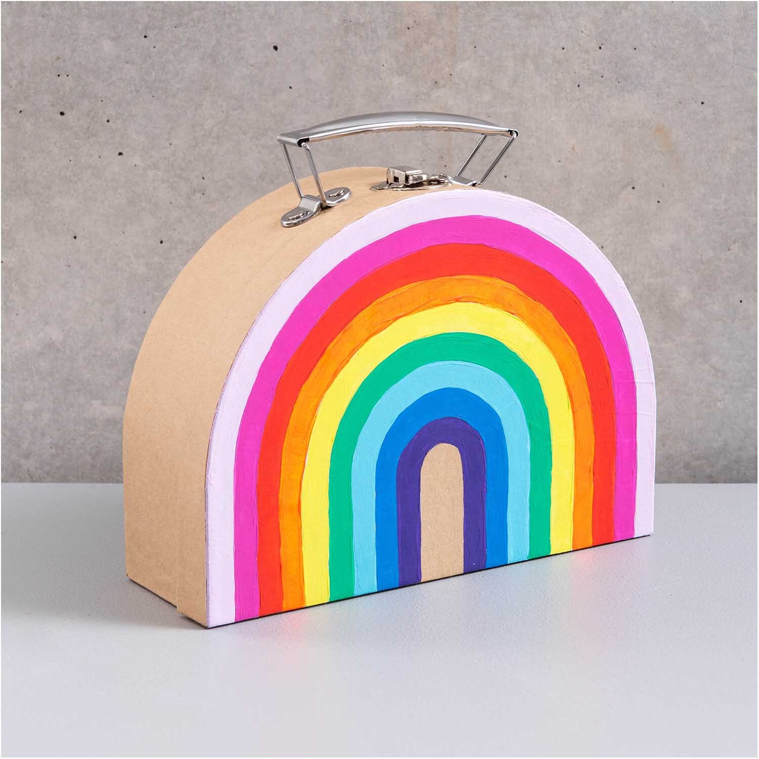 Koffer aus Pappe halbrund natur Größe 20x15x7cm von Rico Design Koffer aus Pappe halbrund natur mit Regenbogenmotiv, ideal für kreative Aufbewahrung. Marke: Rico Design.