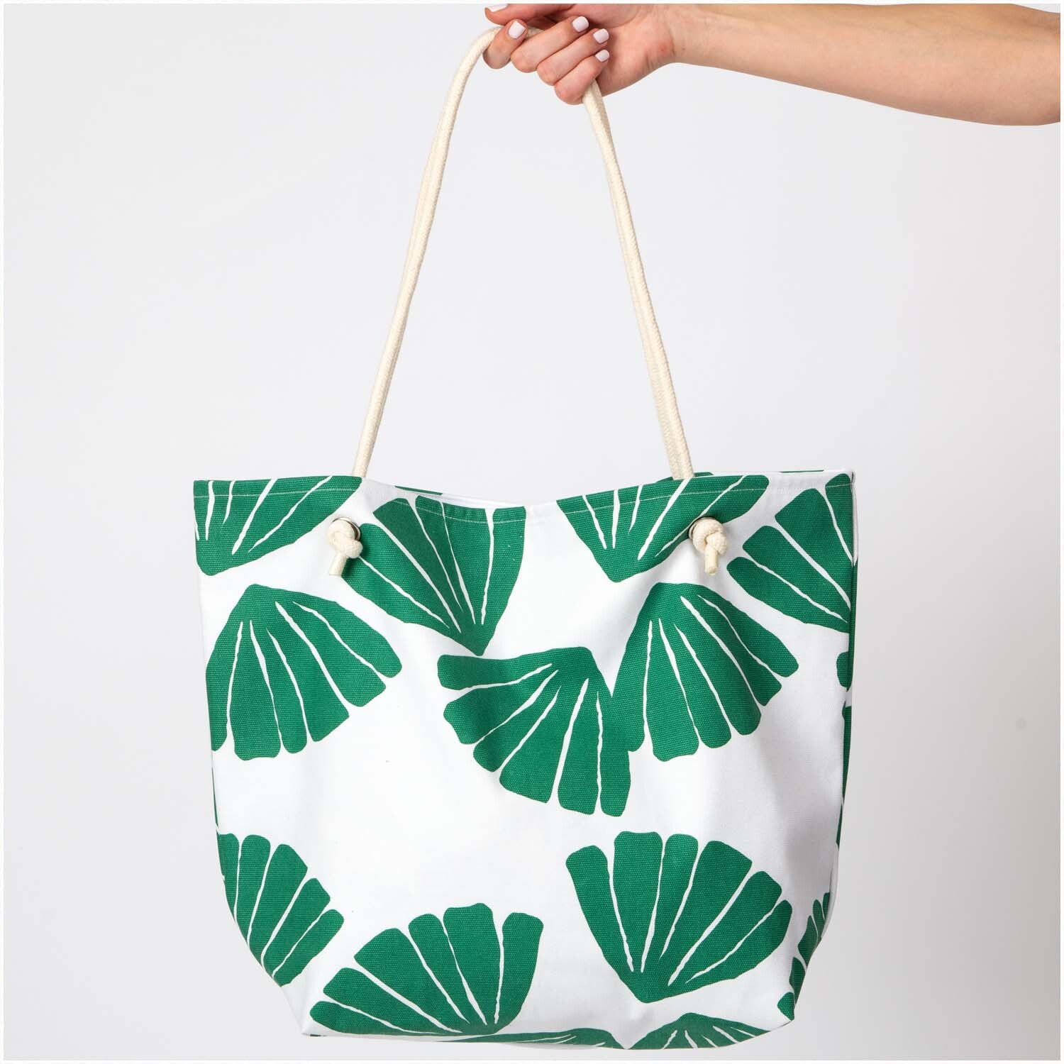 Druckstoff Canvas Aloha Blätter 50x140cm von Rico Design Druckstoff Canvas Aloha Blätter 50x140cm: Tasche mit grünem Blattmuster, gehalten von einer Hand.