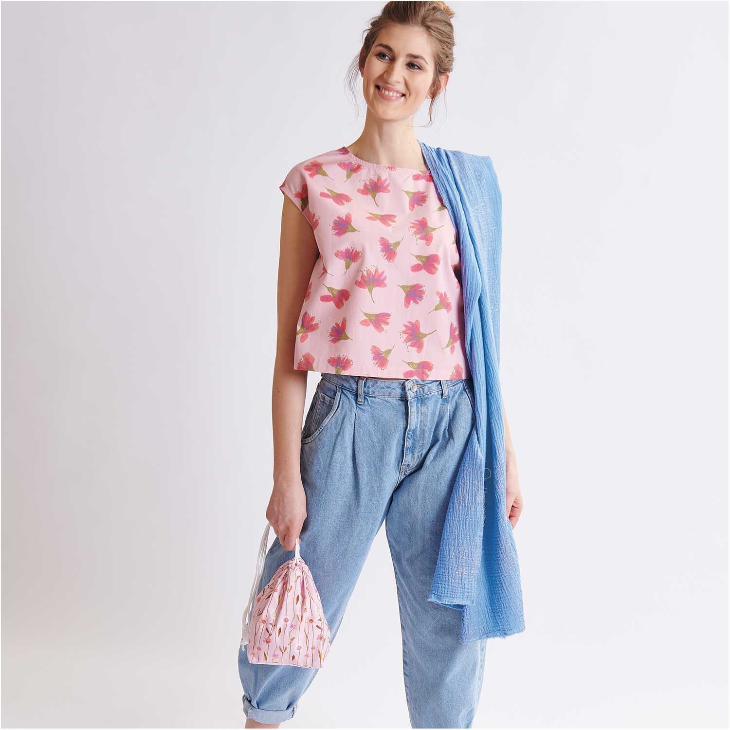 Meterware Krinkelmusselin azur Hot Foil von Rico Design Meterware Krinkelmusselin azur Hot Foil: Frau in lässigem Outfit mit blauem Schal und rosa Oberteil mit Blumenmuster.