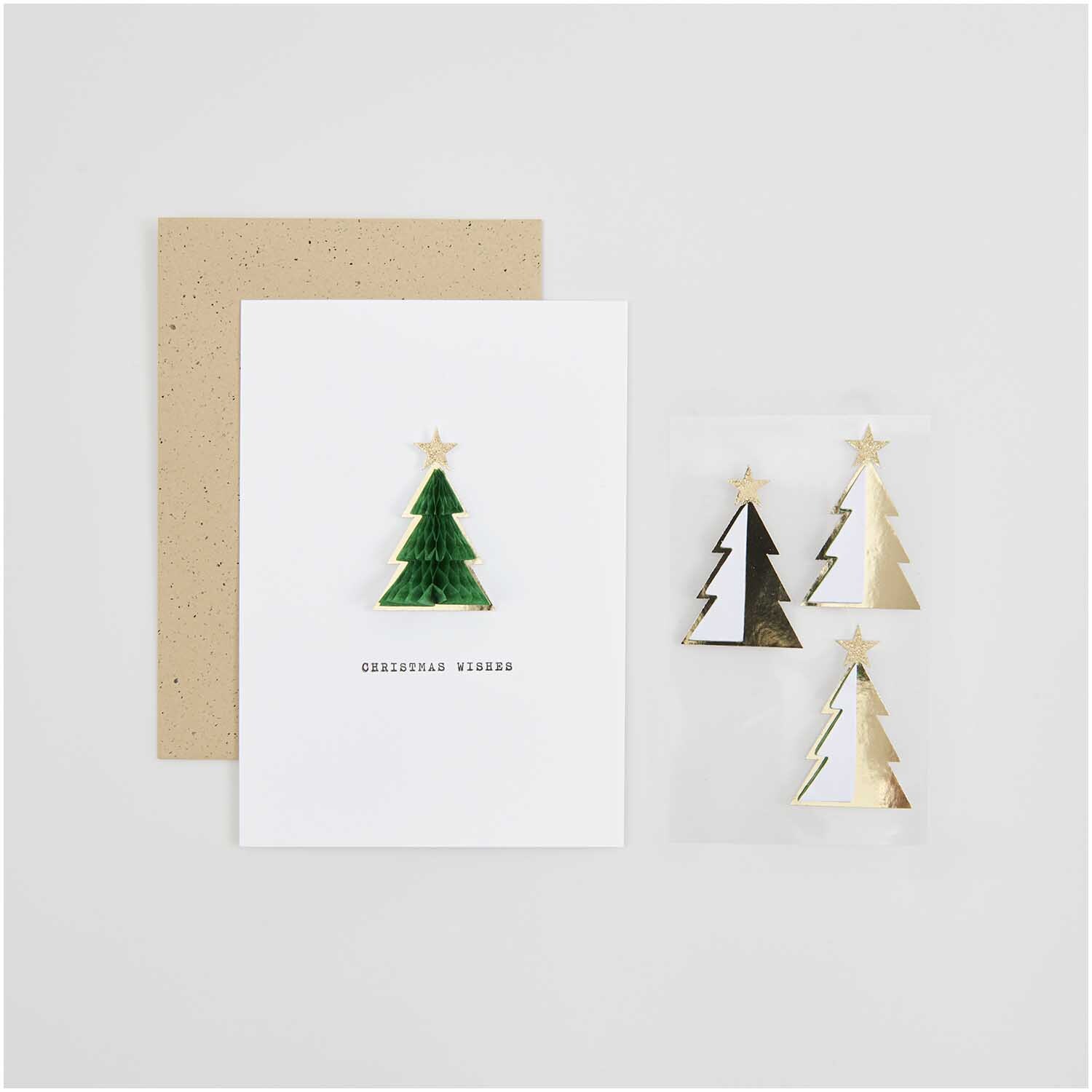 Paper Poetry Wabenpapiersticker Tannen 1 Blatt von Rico Design Paper Poetry Wabenpapiersticker Tannen auf einer Karte mit Umschlag, verziert mit goldenen und grünen Tannenbaumstickern von Rico Design.
