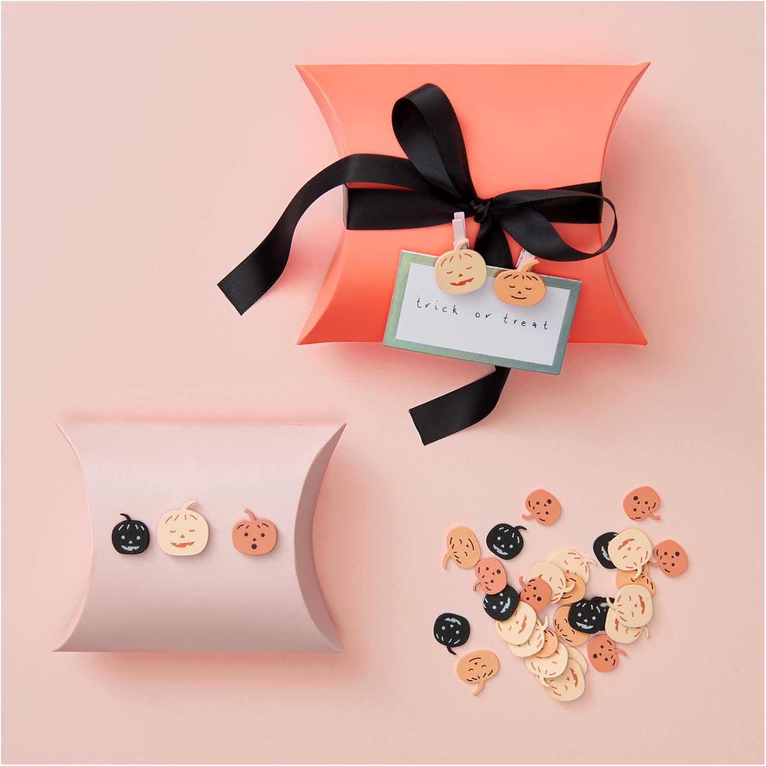Holzclips Kürbis Mix orange-schwarz 8 Stück von Rico Design Holzclips Kürbis Mix: Mehrfarbige Kürbis-Holzclips von Rico Design, dekorativ auf Geschenkboxen arrangiert.