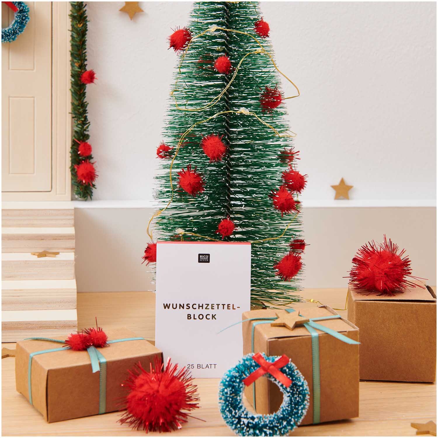 Paper Poetry Wunschzettelblock A8 25 Blatt 100g/m² von Rico Design Paper Poetry Wunschzettelblock A8 vor einem festlich dekorierten Weihnachtsbaum mit Geschenken.
