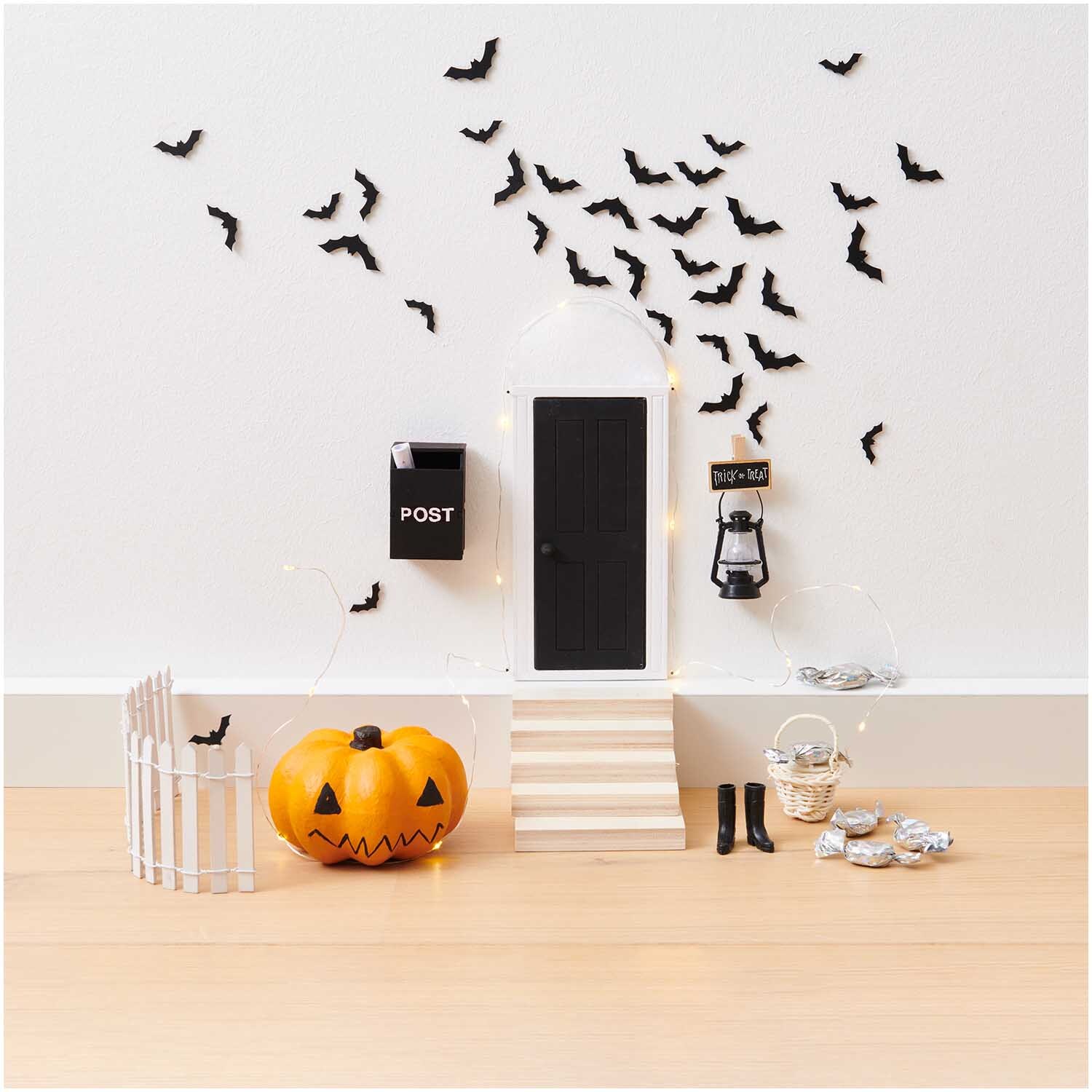 Miniatur Korb mit Henkel 4,5x4,5x6cm Farbe Hell von Rico Design Miniatur Korb mit Henkel neben Halloween-Dekoration: Kürbis, Fledermäuse und Laterne vor einer Tür.