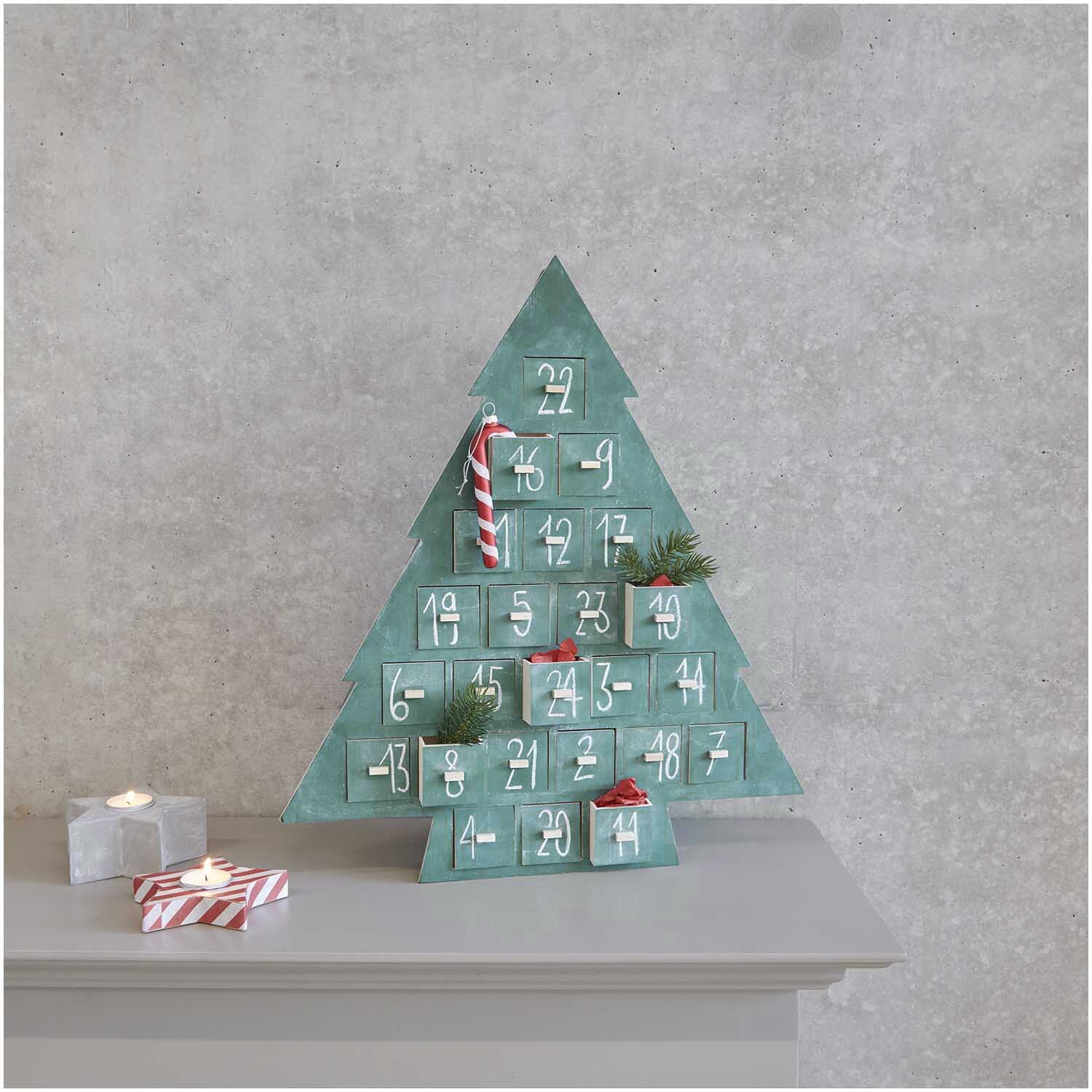 Adventskalender Tanne aus Holz 45x51x5cm von Rico Design Adventskalender Tanne aus Holz mit 24 nummerierten Fächern, dekoriert mit Zweigen und Zuckerstangen, von Rico Design.