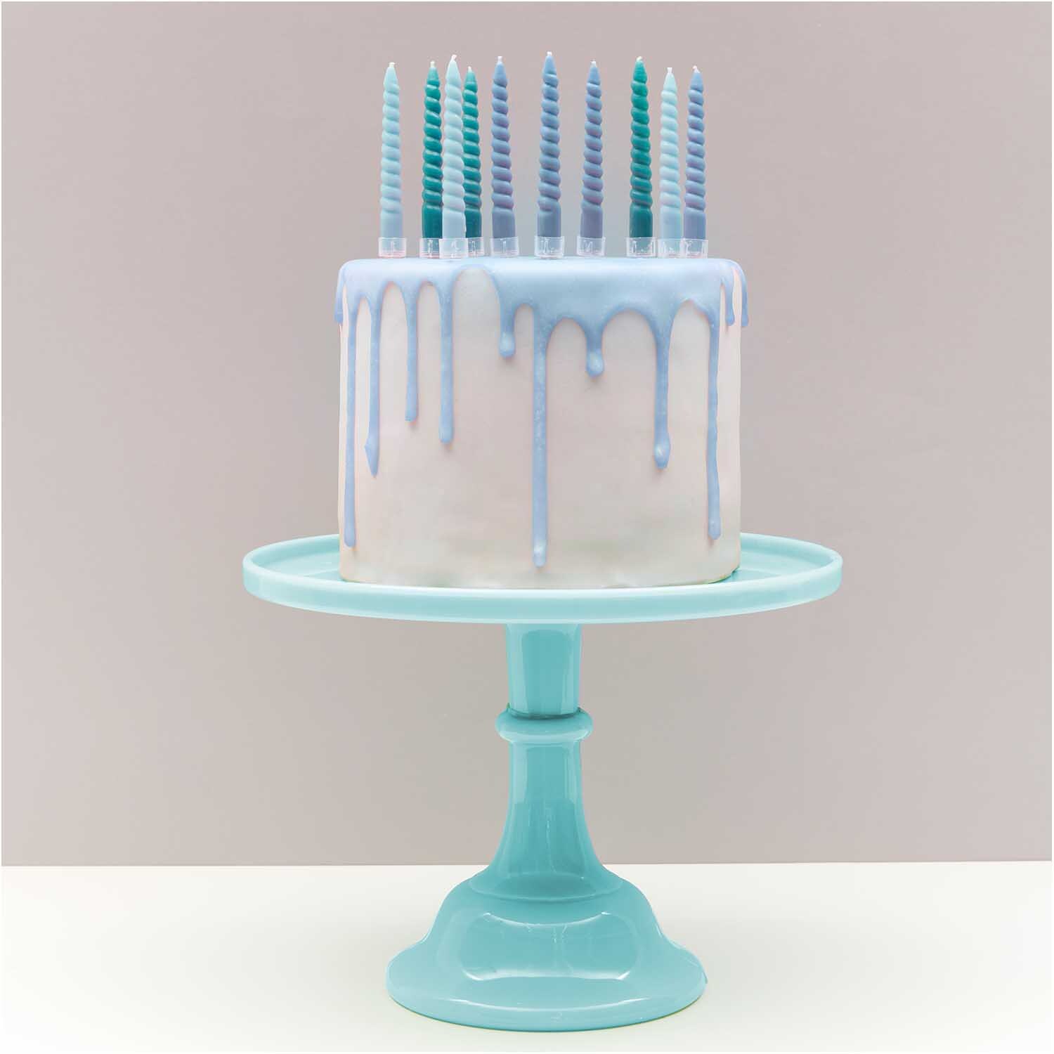 Spiral Kerzenhalter transparent: Eleganter Kuchen mit blauen Kerzen auf türkisfarbenem Ständer.