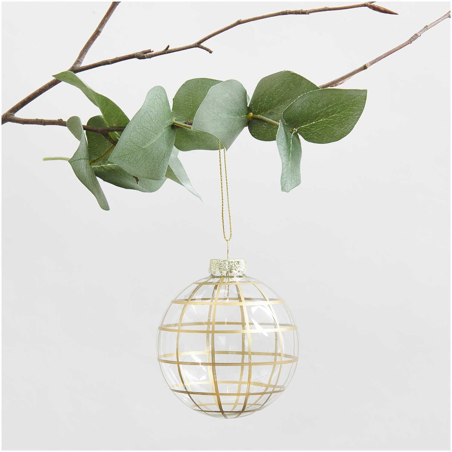Glaskugel Baumschmuck grafisch gold Ø 8cm von Rico Design Glaskugel Baumschmuck grafisch gold Ø 8cm von Rico Design, hängend an einem Ast mit grünen Blättern.