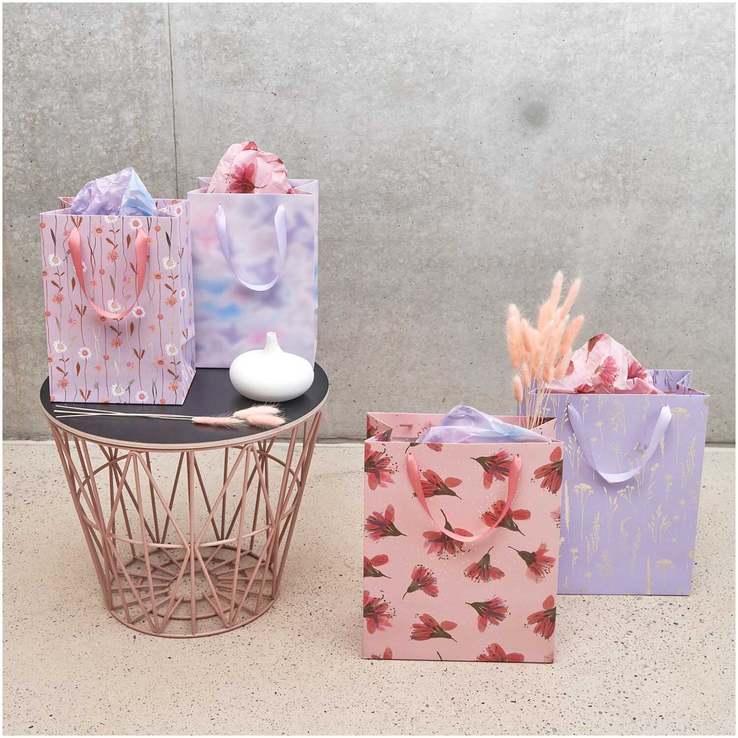 Paper Poetry Geschenktüte Gräser lila 26x32x12cm von Rico Design Paper Poetry Geschenktüte mit Gräsermotiv in Lila von Rico Design, neben anderen Tüten auf einem Tisch arrangiert.