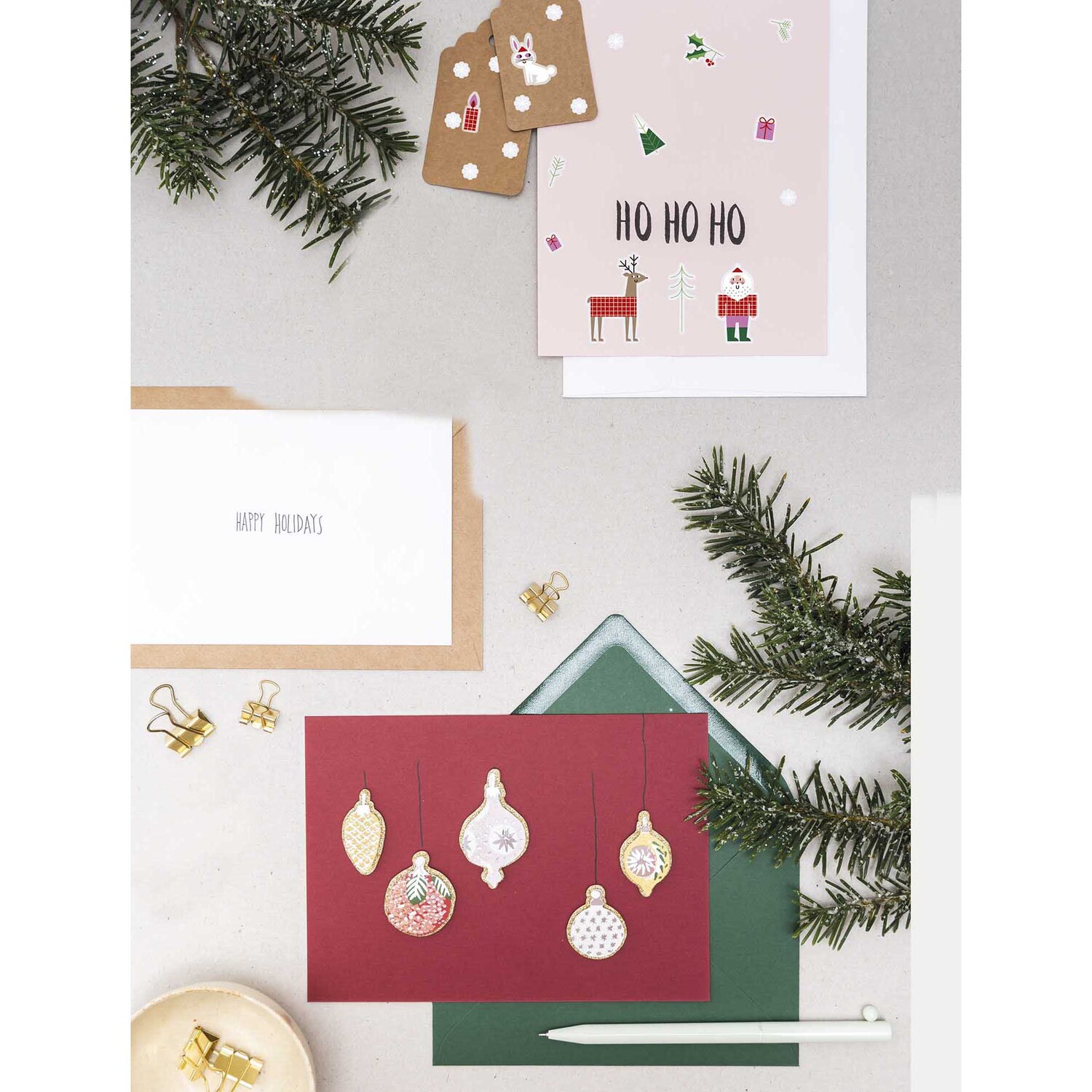 Paper Poetry Gelsticker Weihnachtsmann 1 Blatt von Rico Design Paper Poetry Gelsticker Weihnachtsmann 1 Blatt: Mehrfarbige Weihnachtskarten mit Tannenzweigen und Dekorationen auf einem Tisch arrangiert.