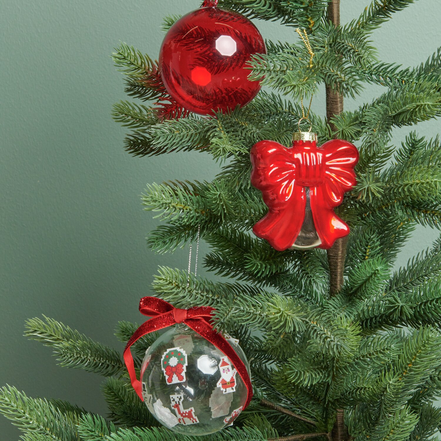 Glaskugel am Weihnachtsbaum mit rotem Glashänger und Schleife, dekoriert mit Paper Poetry Samtband.