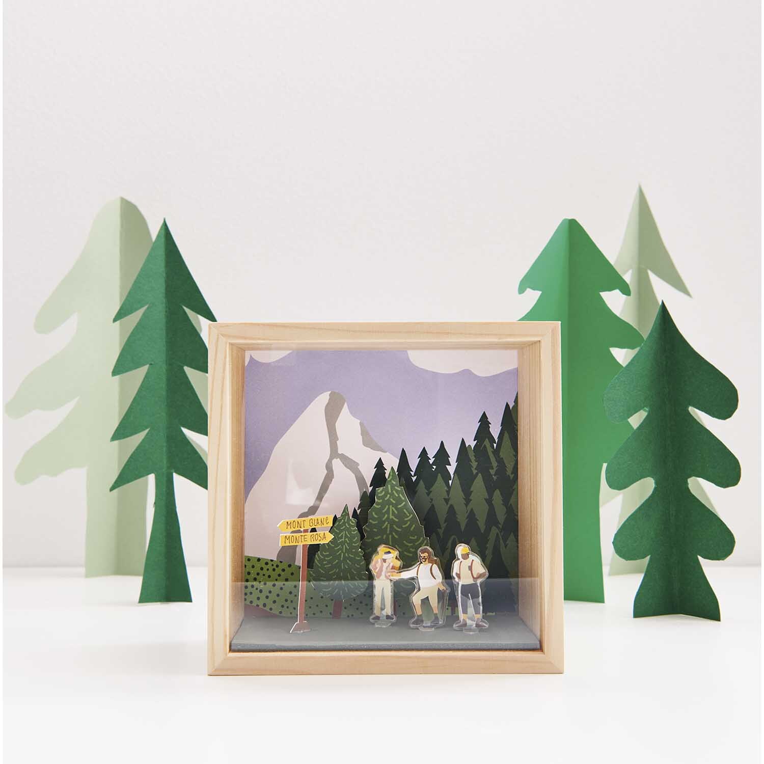 Figurico Gelsticker Outdoor Aktivitäten von Rico Design Figurico Gelsticker Outdoor Aktivitäten: Holzrahmen mit Berglandschaft und Wanderern, umgeben von grünen Bäumen. Ideal für kreative Dekorationen.