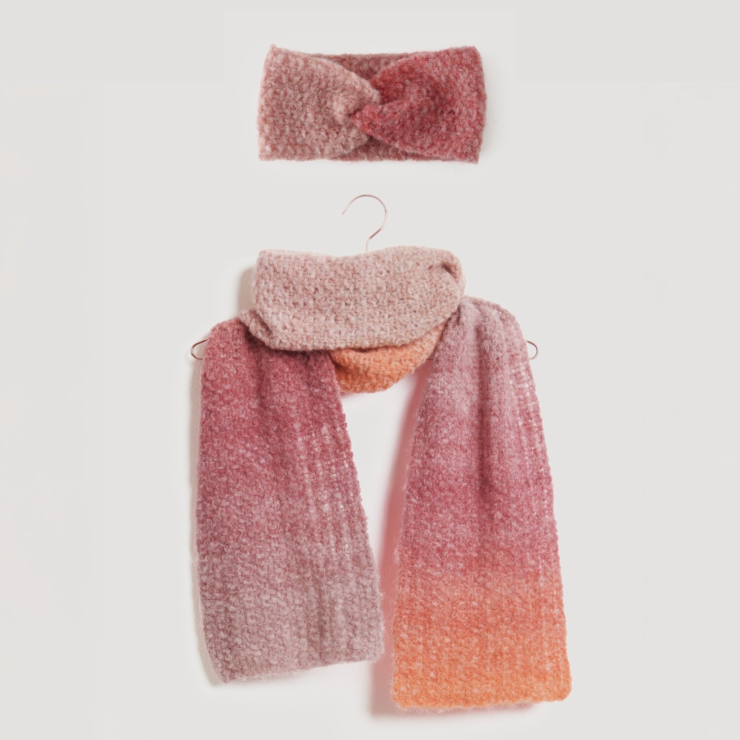 Fashion Alpaca Superfine Heavens Big Cloud 100g 280m Farbe Sundown von Rico Design Stirnband und Schal in sanften Rosa- und Orangetönen, aus weichem Material. Perfekt für kühle Tage. Modell Legeware, ideal für stilvolle Herbst- und Winteroutfits.