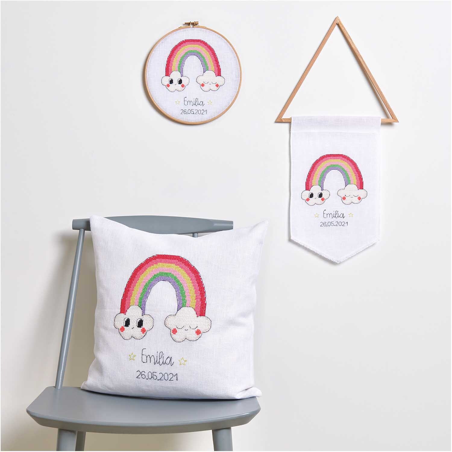 Cercle à broder 18cm from Rico Design Stickring mit Regenbogenmotiv und Wolken, dekorativ auf einem Stuhl platziert, 18 cm Durchmesser.