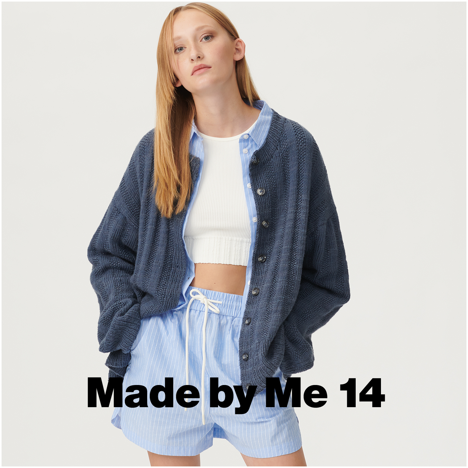 Fashion Cottony: Frau in marineblauer Strickjacke von Rico Design, kombiniert mit hellblauen Shorts.