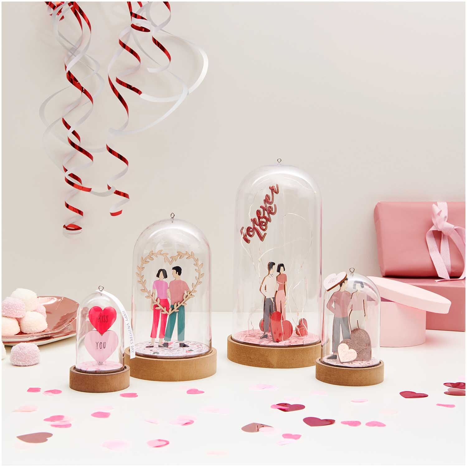 Dekohaube mit Sockel 5,5x11cm Gr. S von Rico Design Dekohaube mit Sockel 5,5x11cm Gr. S zeigt romantische Szenen unter Glas, umgeben von rosa Geschenken und Dekorationen. Ideal für Valentinstag.