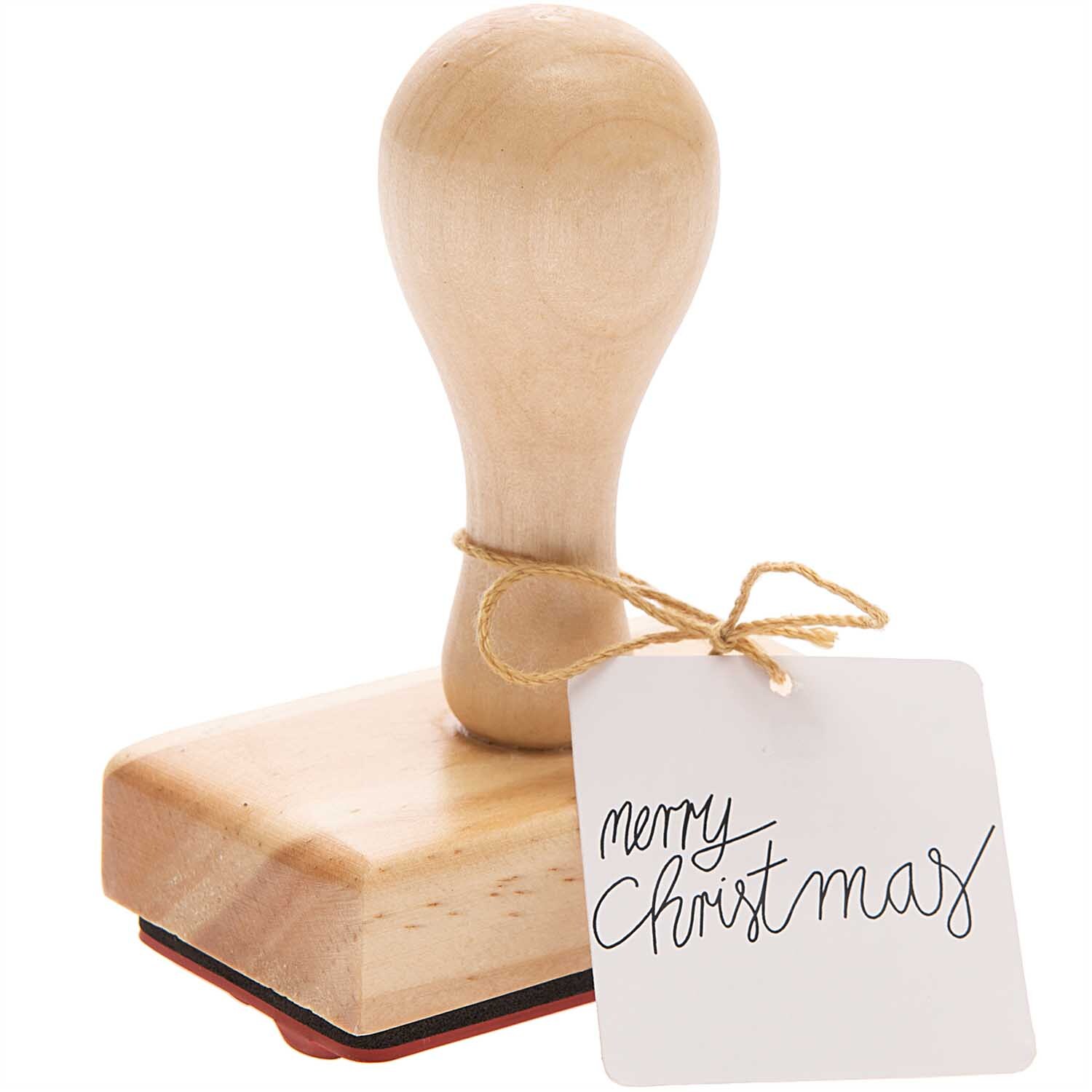Stempel Merry Christmas 7x4cm von Rico Design, braun, mit Holzgriff und festlichem Grußetikett. Ideal für kreative Weihnachtsprojekte.