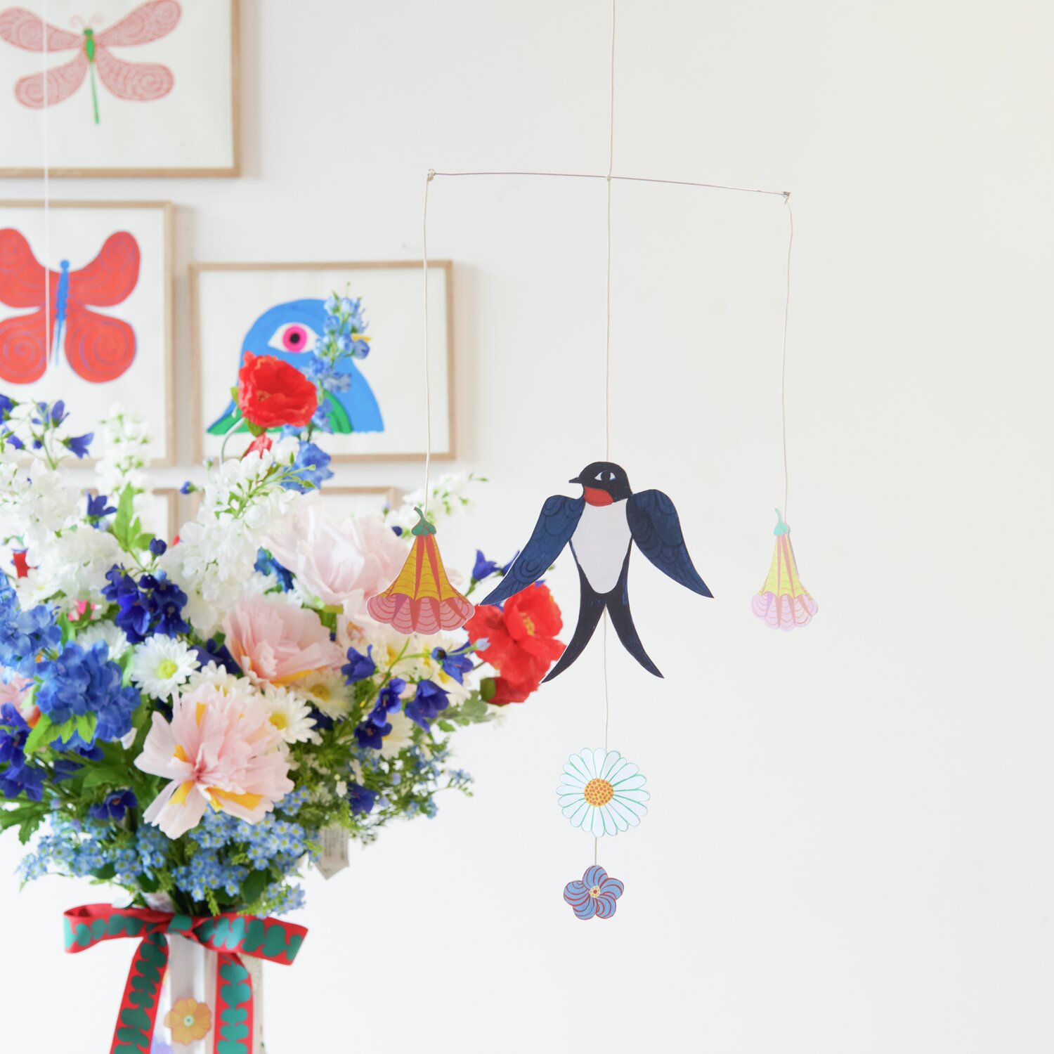 Bastelpapierblock Midsommar Magic 23 Blatt von Rico Design Bastelpapierblock Midsommar Magic: Ein Mobile mit Schwalbe und Blumen, umgeben von bunten Blumensträußen. Ideal für kreative Dekorationen.