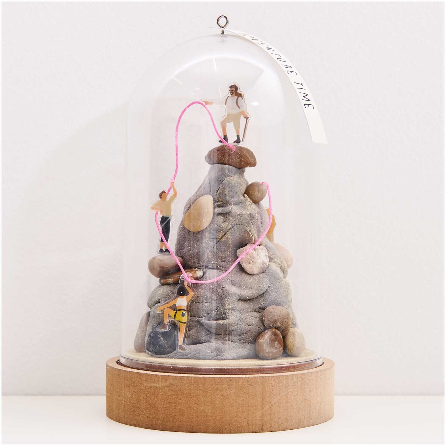 Figurico Modelliermasse 28g Farbe Grau von Rico Design Figurico Modelliermasse 28g: Miniaturfiguren klettern auf Steinhaufen unter Glaskuppel, dekorativ und kreativ.