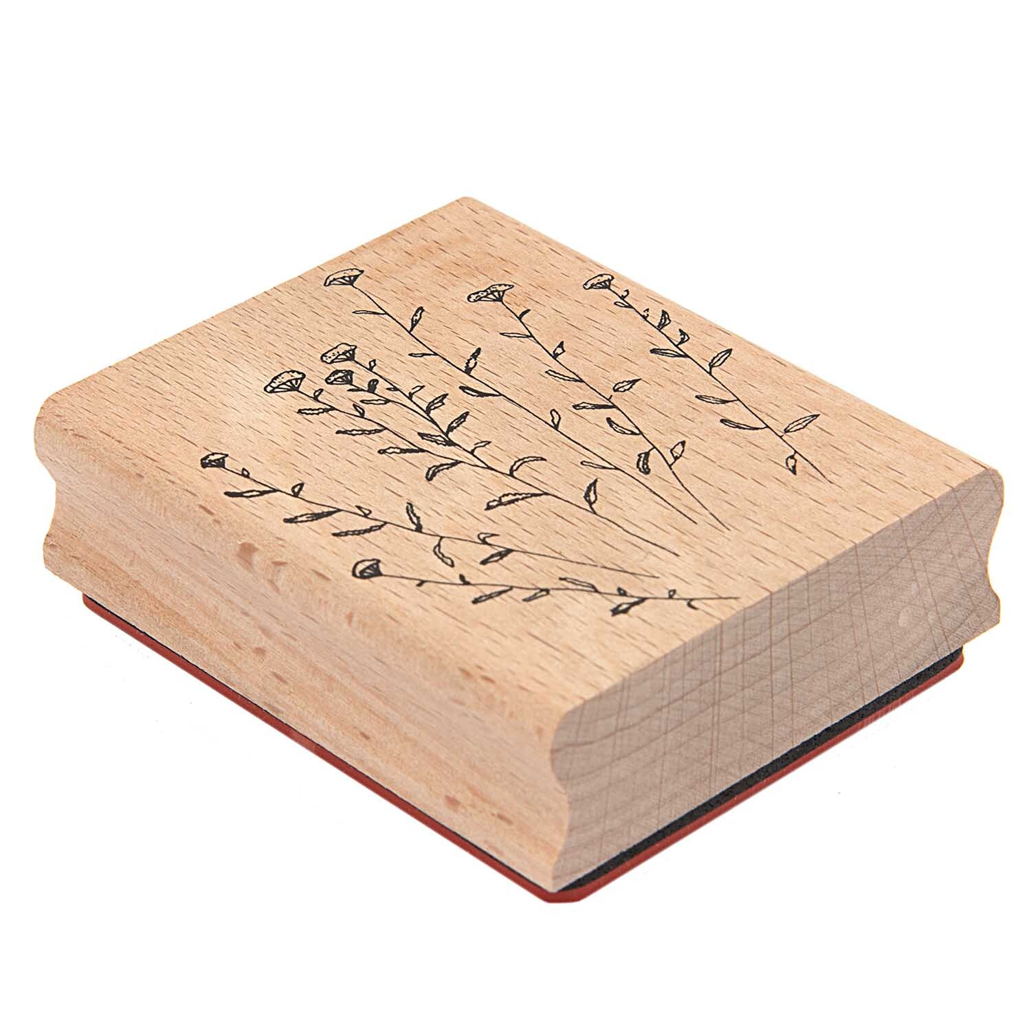 Paper Poetry Stempel Anis zeigt filigrane Blumenmotive auf hellem Holz, ideal für kreative Projekte.