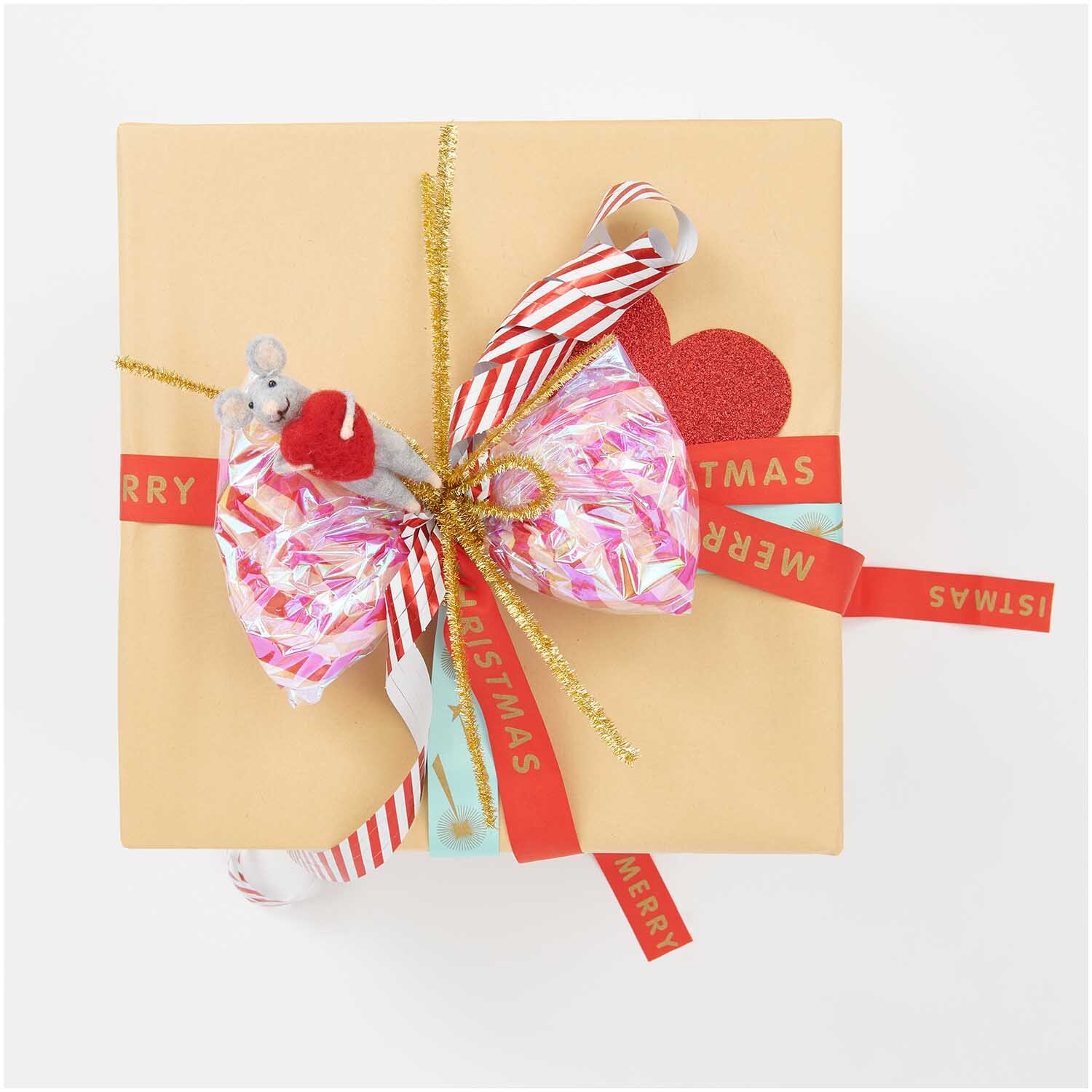 Luftschlangen Streifen rot-weiß 3,8m von Rico Design Luftschlangen Streifen rot-weiß 3,8m von Rico Design dekorieren ein Geschenk mit buntem Papier und goldenen Akzenten.