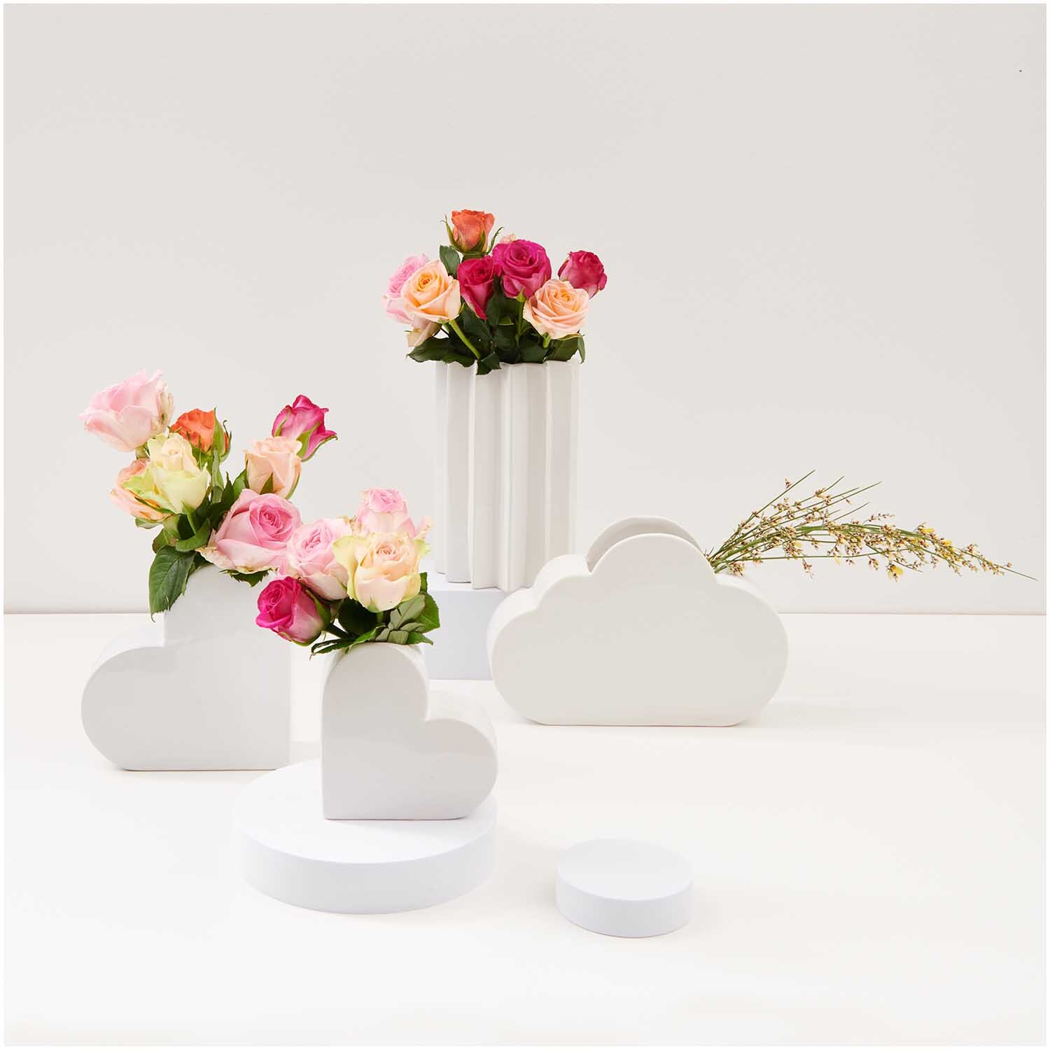 Keramik Vase Herz klein 12x5,5x12cm Farbe Weiß von Rico Design Keramik Vase Herz klein 12x5,5x12cm von Rico Design in Weiß, umgeben von Blumenarrangements.