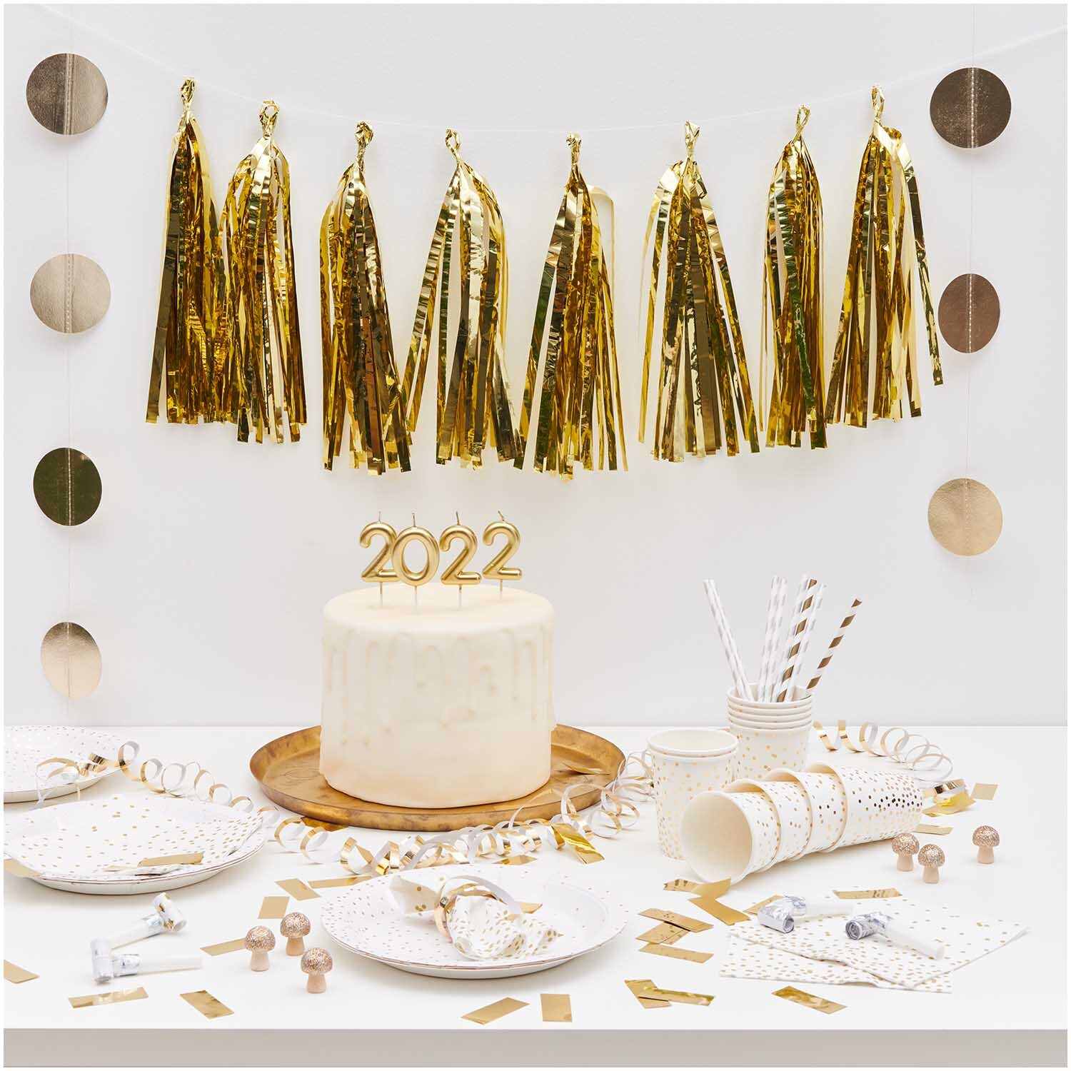 Paper Poetry Girlande Quasten gold 2,8m von Rico Design Paper Poetry Girlande Quasten gold 2,8m von Rico Design dekoriert eine festliche Tafel mit goldenen Akzenten und einer Torte mit der Zahl 2022.
