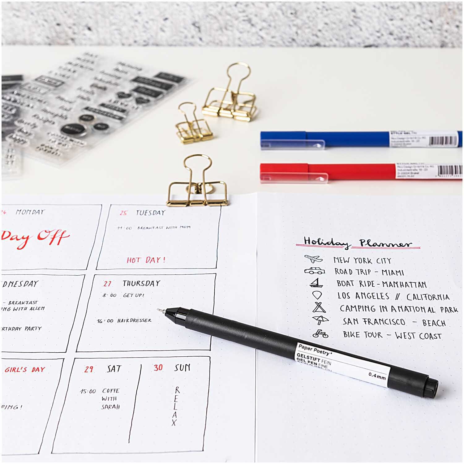 Paper Poetry Bullet Diary Schablone zeigt Planer mit Stiften, Clips und transparenten Schablonen von Rico Design auf einem Schreibtisch.