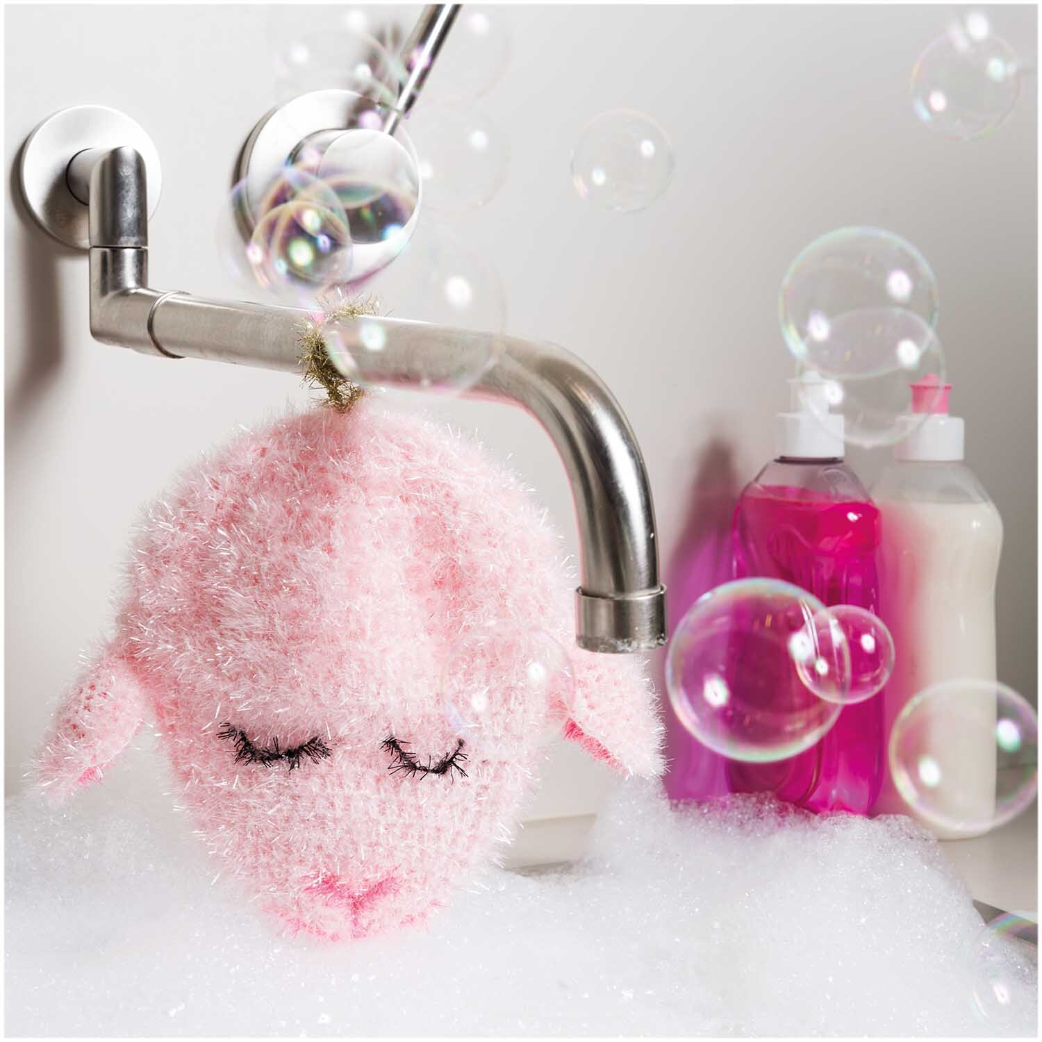 Creative Bubble: Flauschiger Schwamm in Schaf-Form hängt an Wasserhahn, umgeben von Seifenblasen. Ideal für kreative Badeerlebnisse.