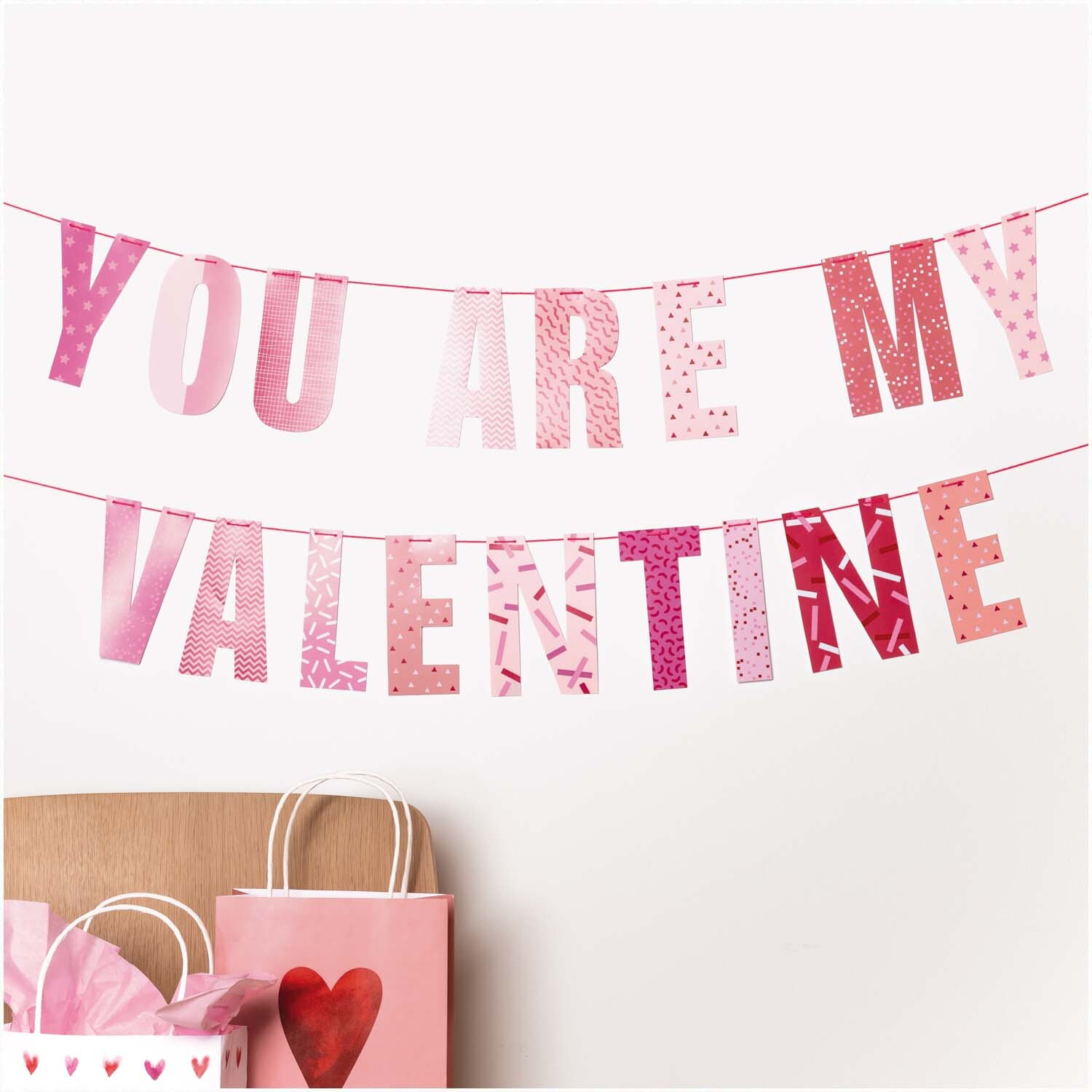 Paper Poetry Girlande mit dem Schriftzug "You are my valentine" in Rosa- und Rottönen von Rico Design.