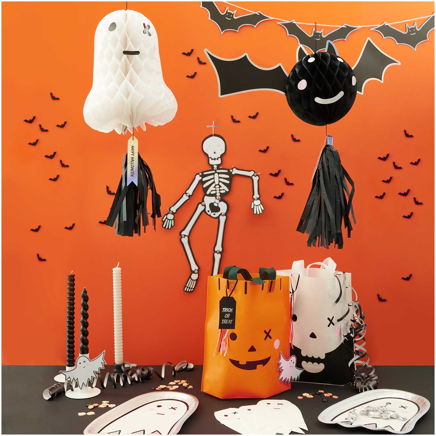 Paper Poetry Geschenktüte Totenschädel 28x30cm von Rico Design Paper Poetry Geschenktüte Totenschädel 28x30cm vor Halloween-Dekoration mit Skelett und Fledermäusen auf orangefarbenem Hintergrund.